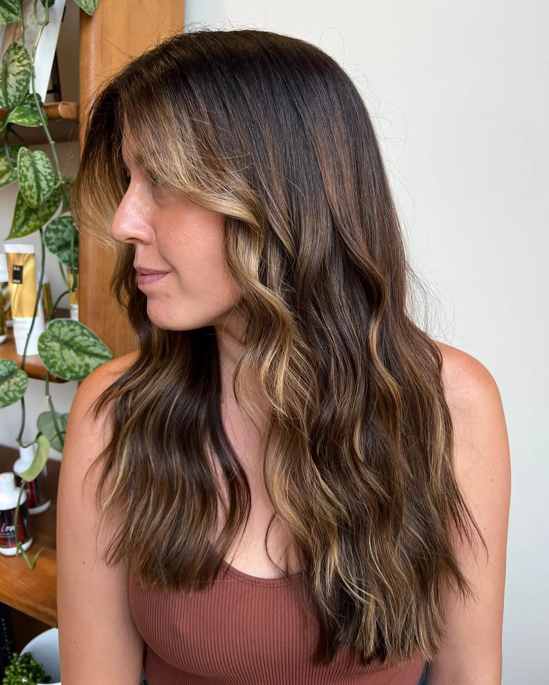 Long, wavy hairstyle with face-framing blonde highlights achieved using a balayage technique. 1