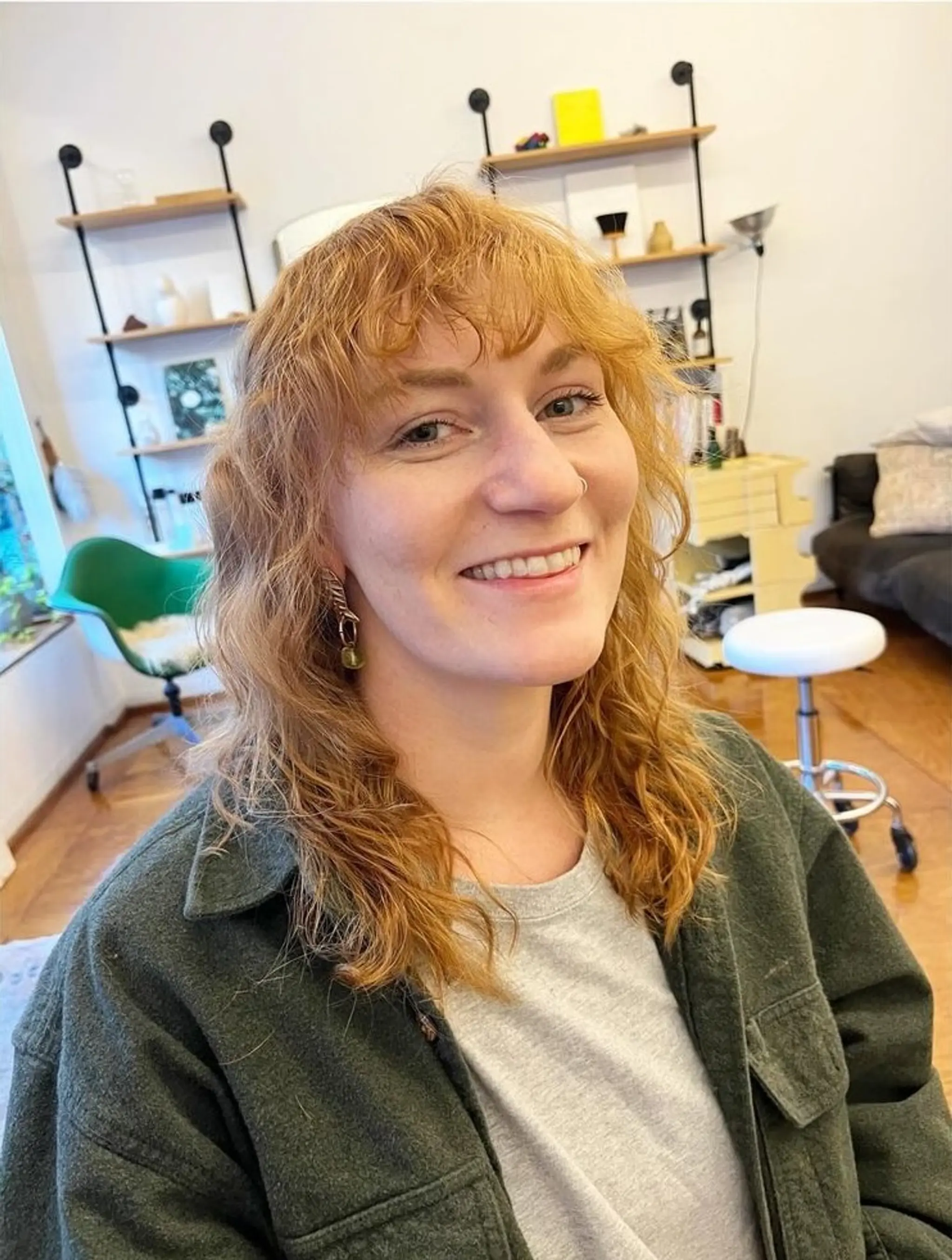 Medium-length copper-red hair with soft waves and front bangs, showcasing natural texture.