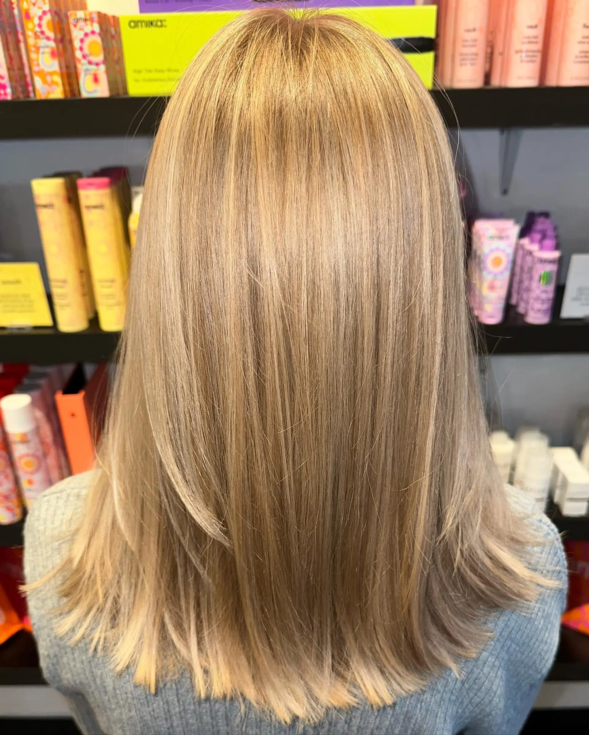 A medium-length straight hairstyle featuring warm blonde highlights and dimensional lowlights with soft layered ends. 1