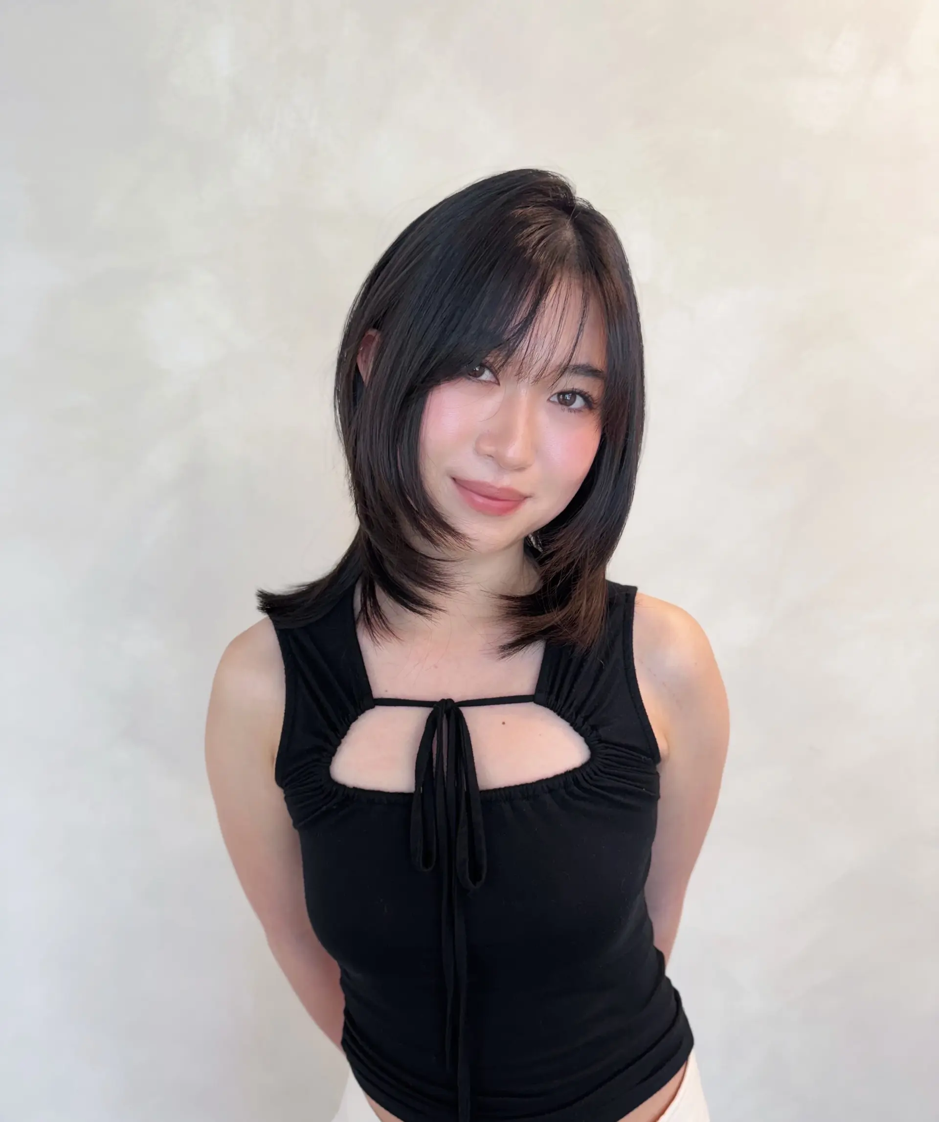 Medium-length layered haircut with face-framing feathered ends and see-through fringe. 1