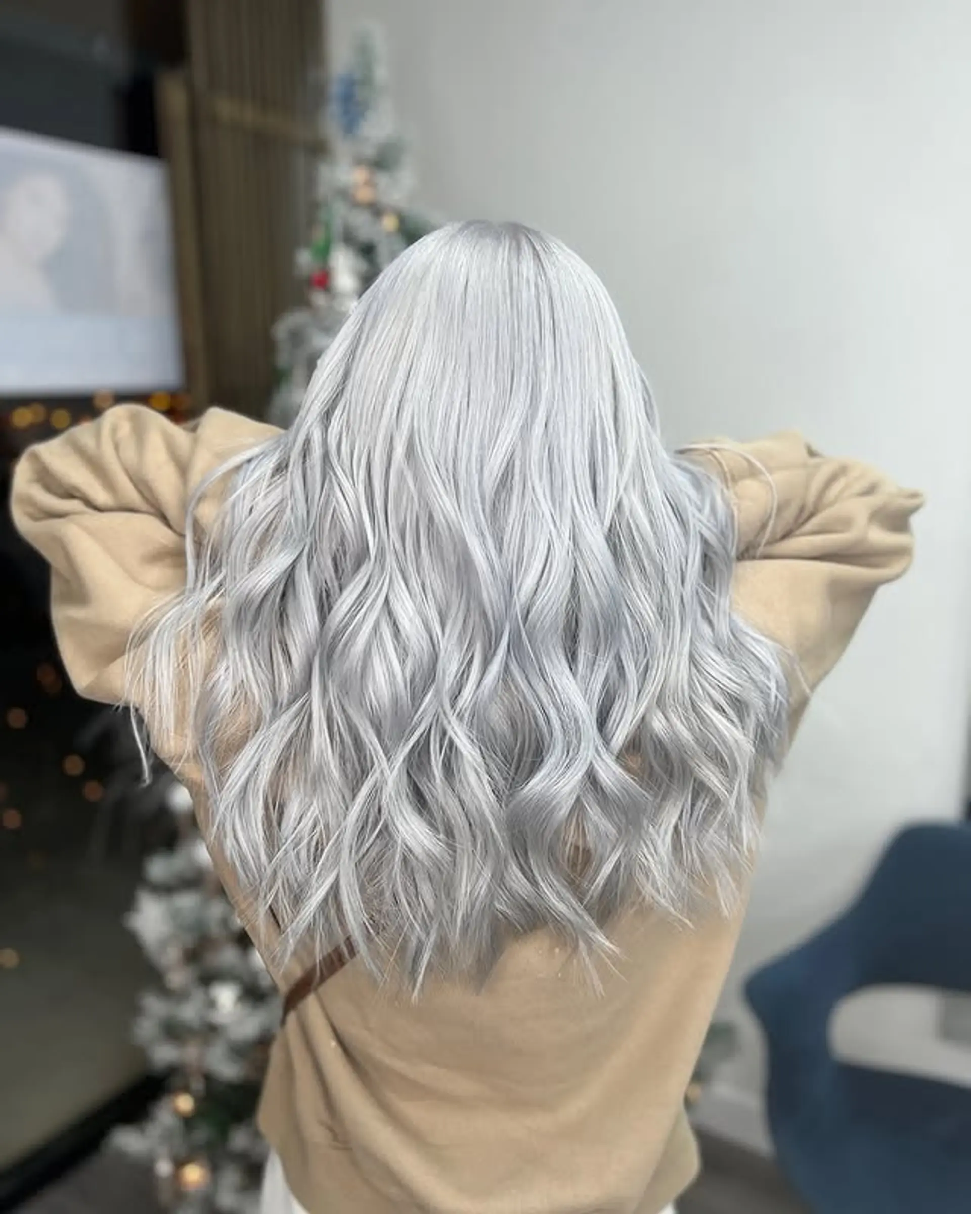 A glamorous long wavy hairstyle with icy platinum silver tones that cascade down the back. 1
