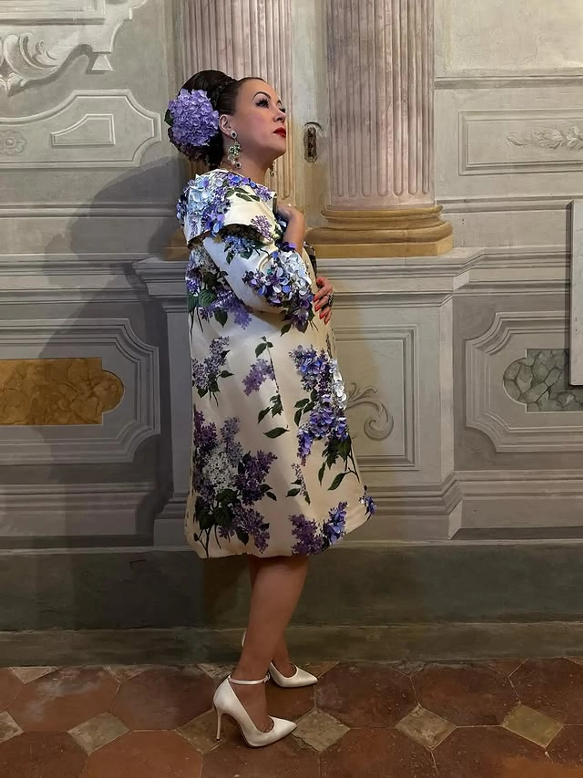 A beautifully styled updo with a braided accent and a floral accessory. 1