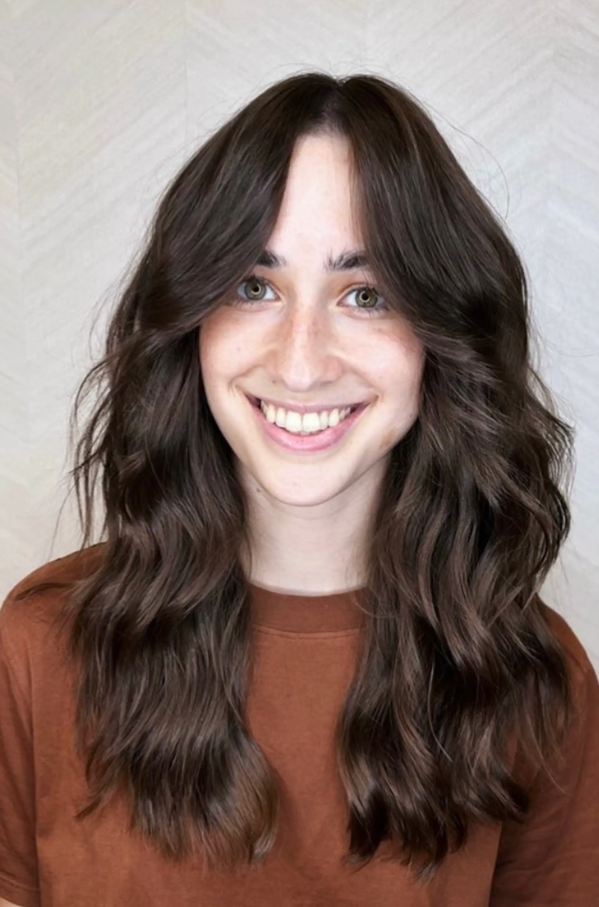 Long, dark brown, wavy hair parted down the center with face-framing layers.

Cut and style by @juliamannino_hair 1
