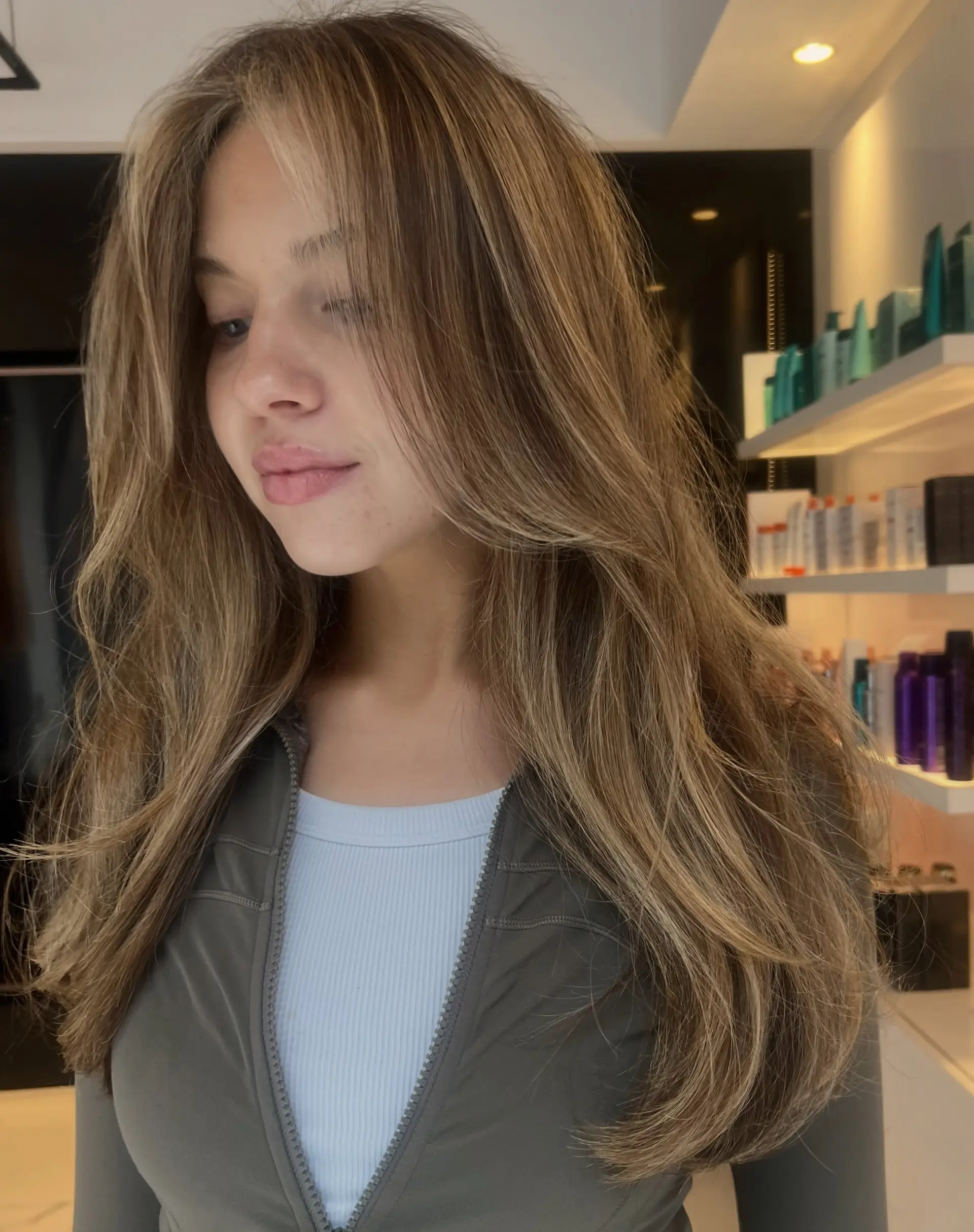 Long dimensional bronde hair featuring soft warm honey highlights and curtain face-framing layers. 1