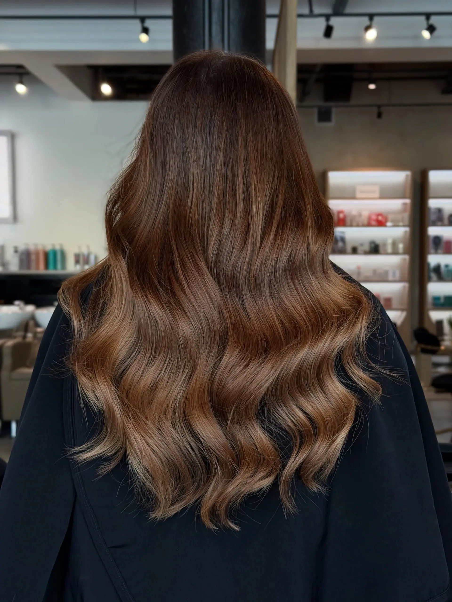 Long chocolate brown hair styled in soft, polished waves with subtle warm balayage highlights. 1