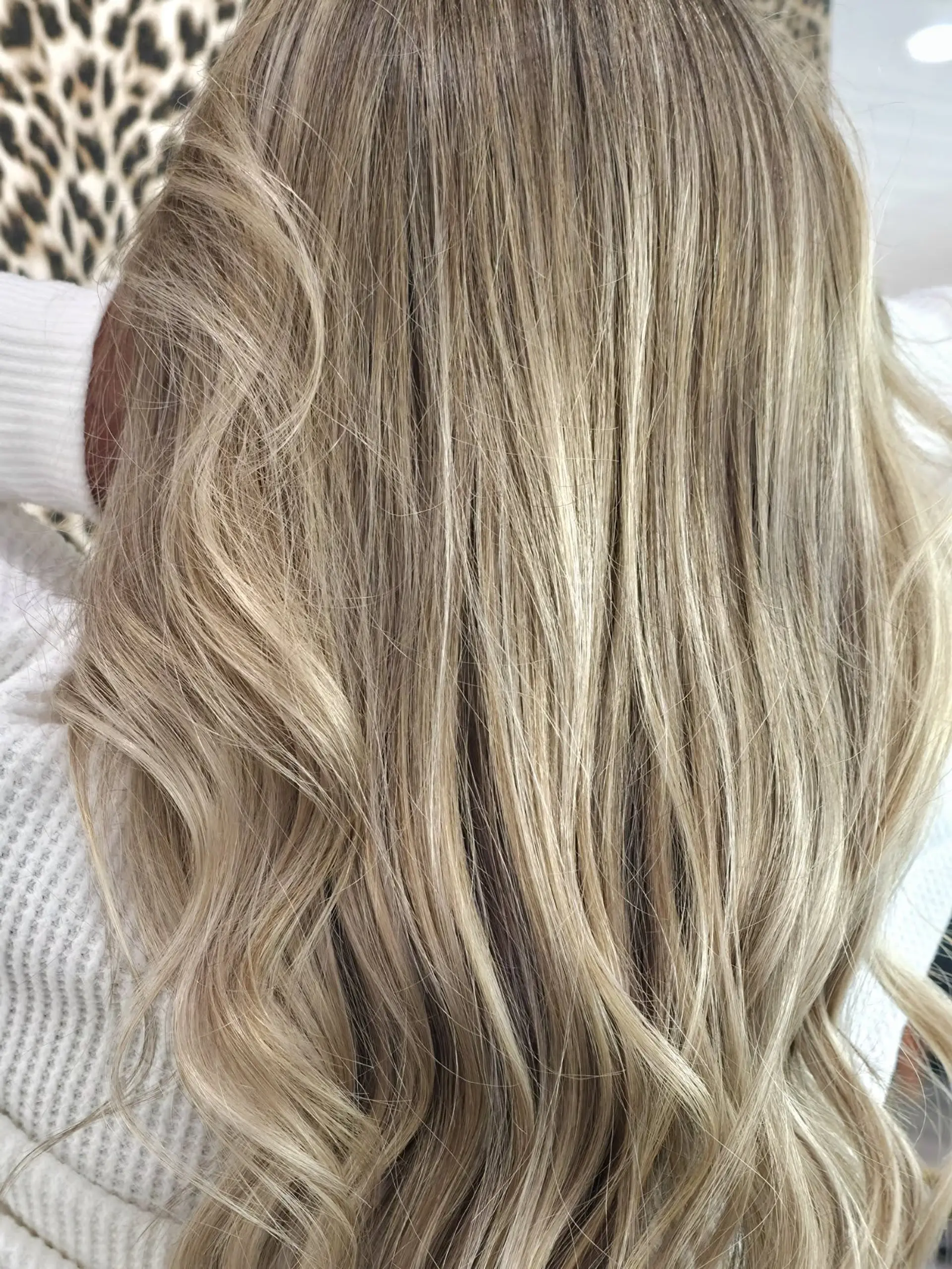 Long ash blonde hair styled in soft, flowing waves with finely woven highlights. 1