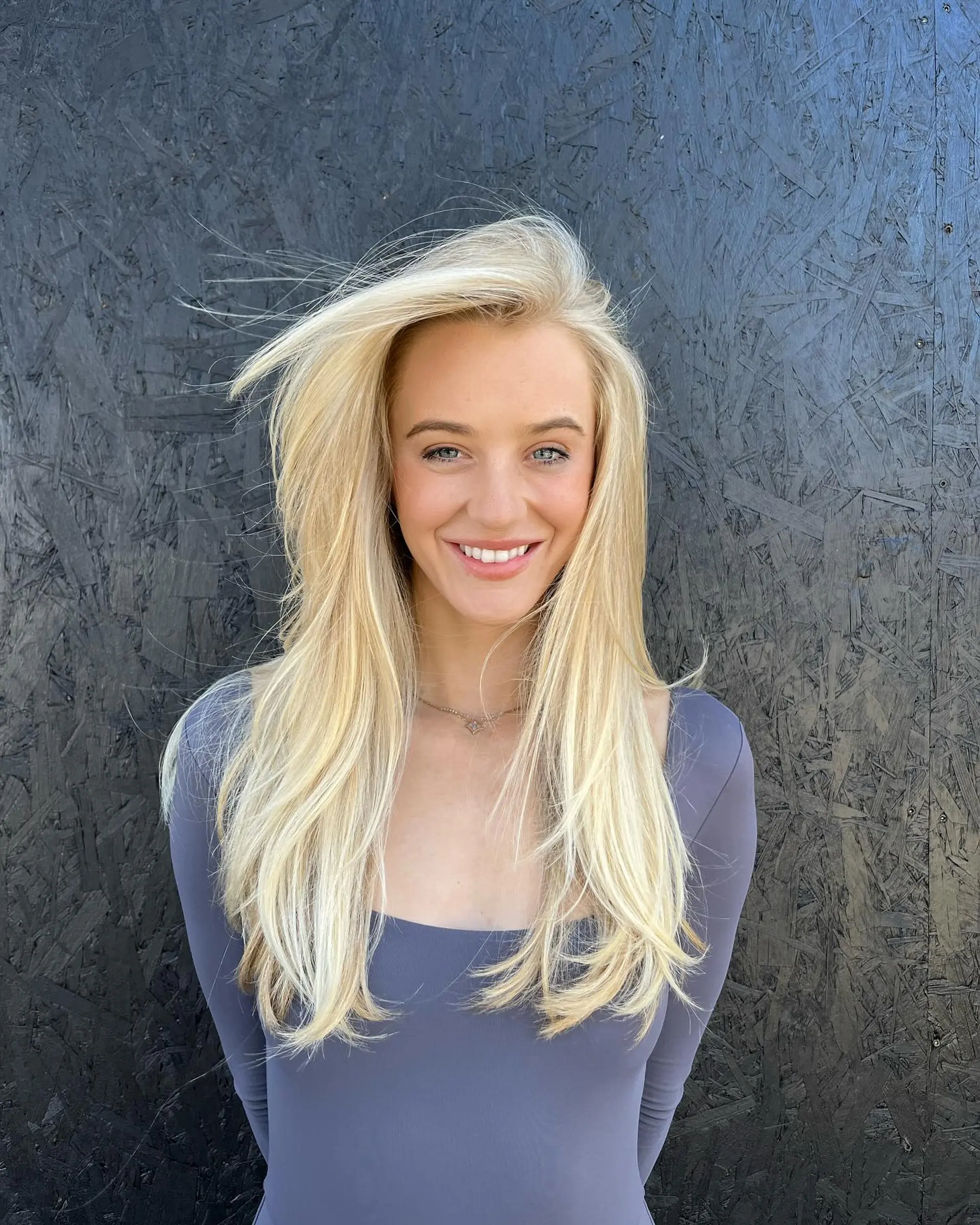 Long, bright blonde layered hair styled in a sleek, voluminous blowout. 1