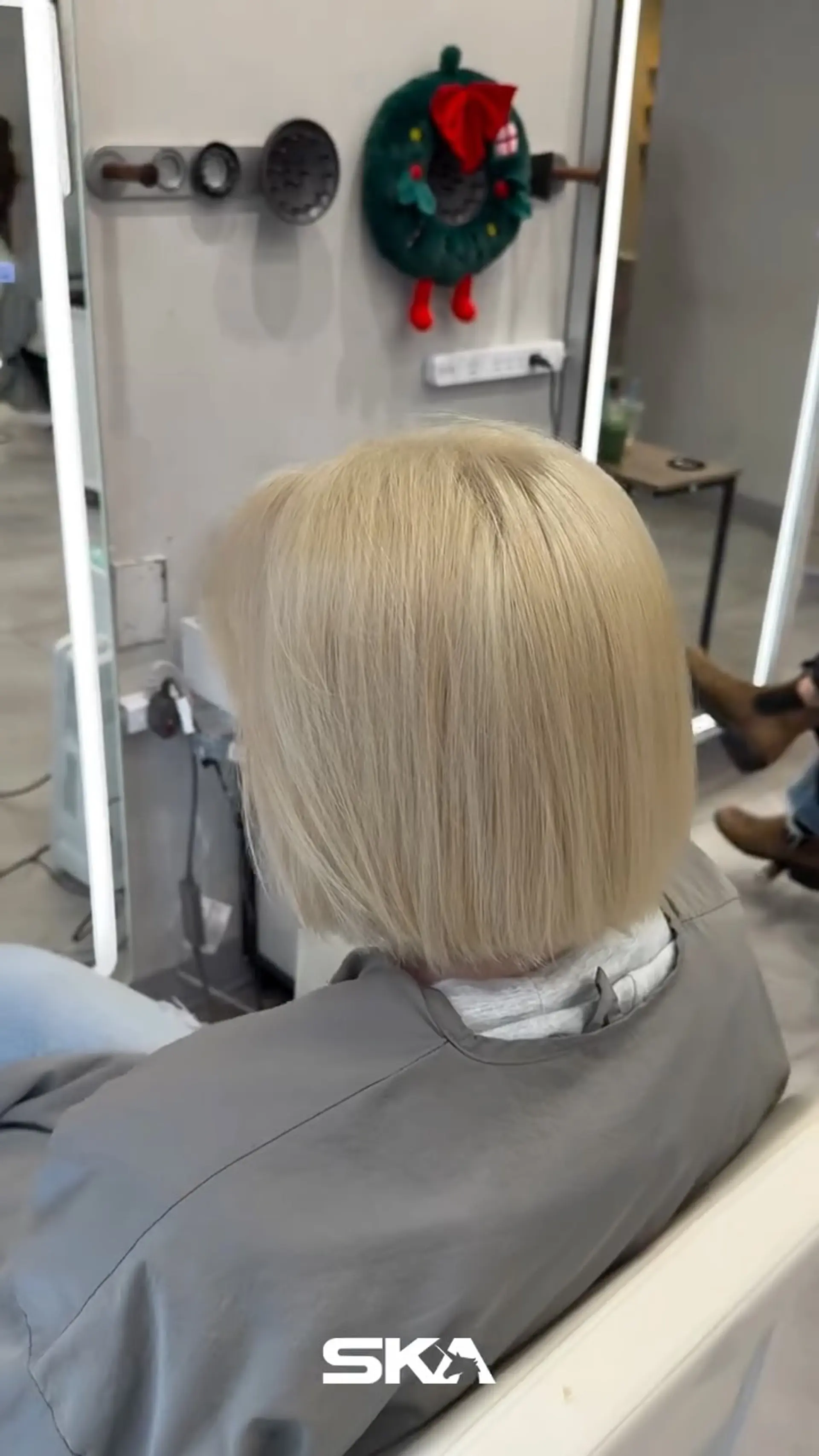 A sleek, straight platinum blonde blunt bob cut evenly at the nape of the neck. 1