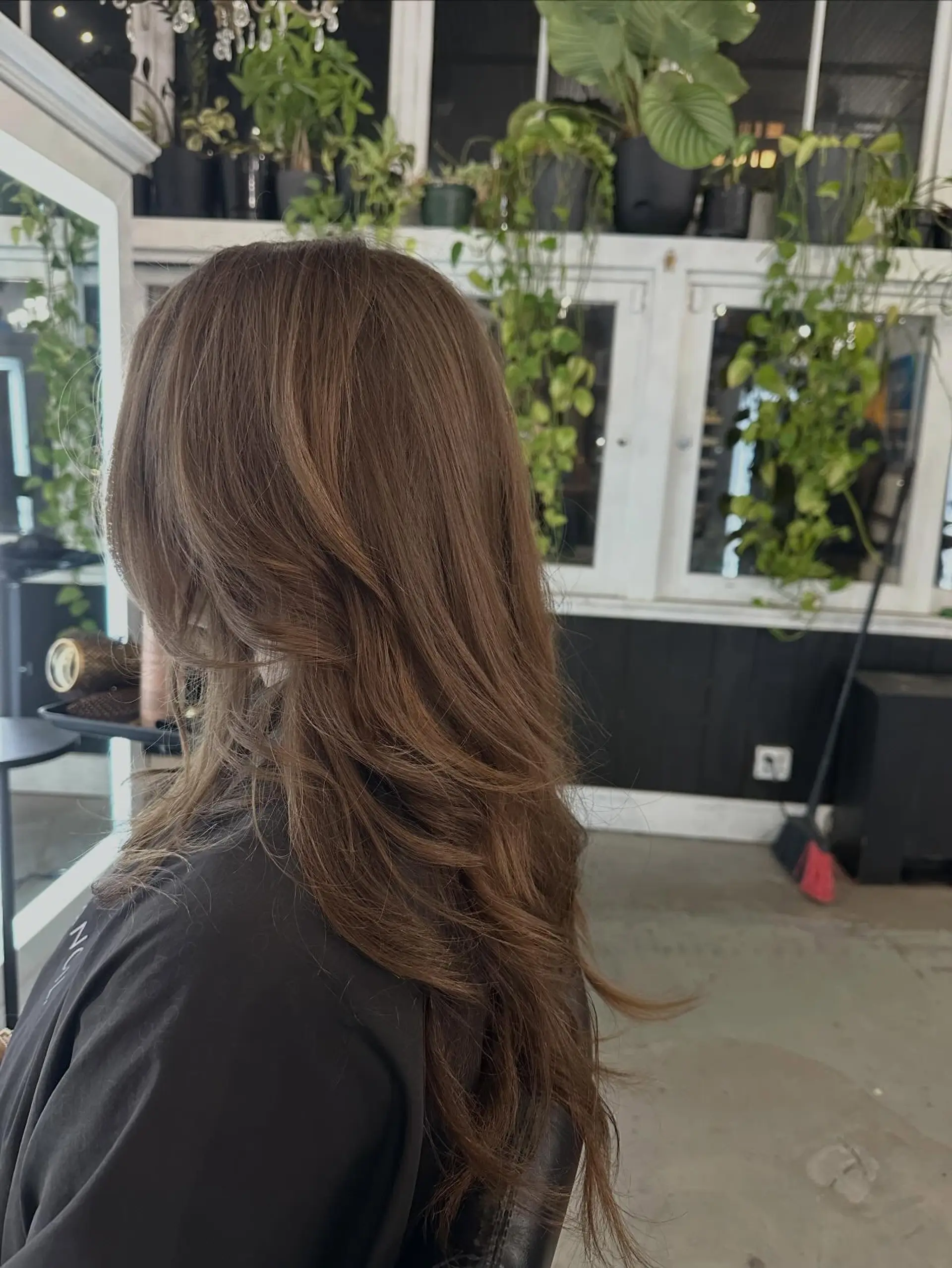 Long brown hair cut into flowing, face-framing layers with a smooth blowout finish. 1
