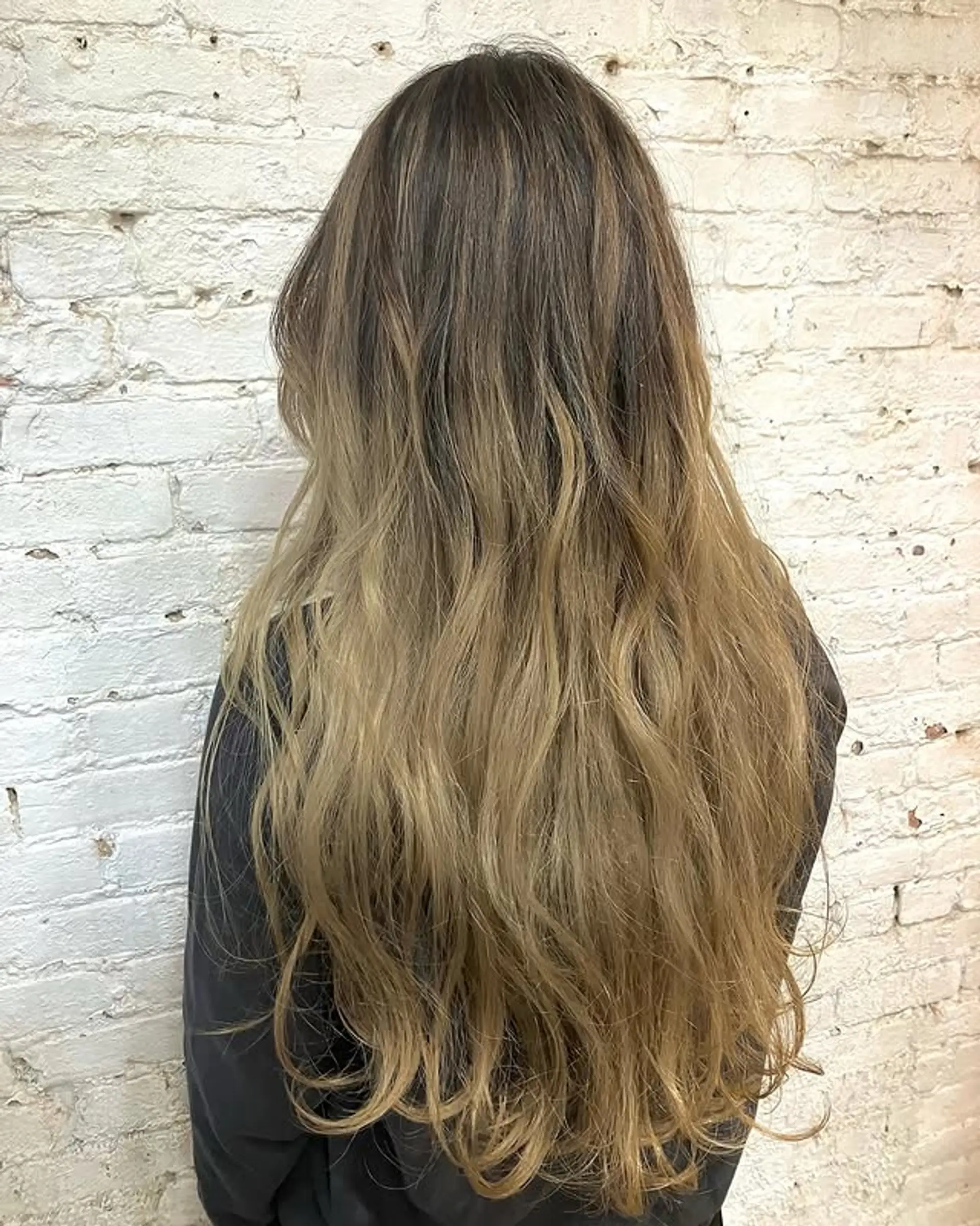 Long, wavy hair with a bronde balayage, featuring subtle layers. 1