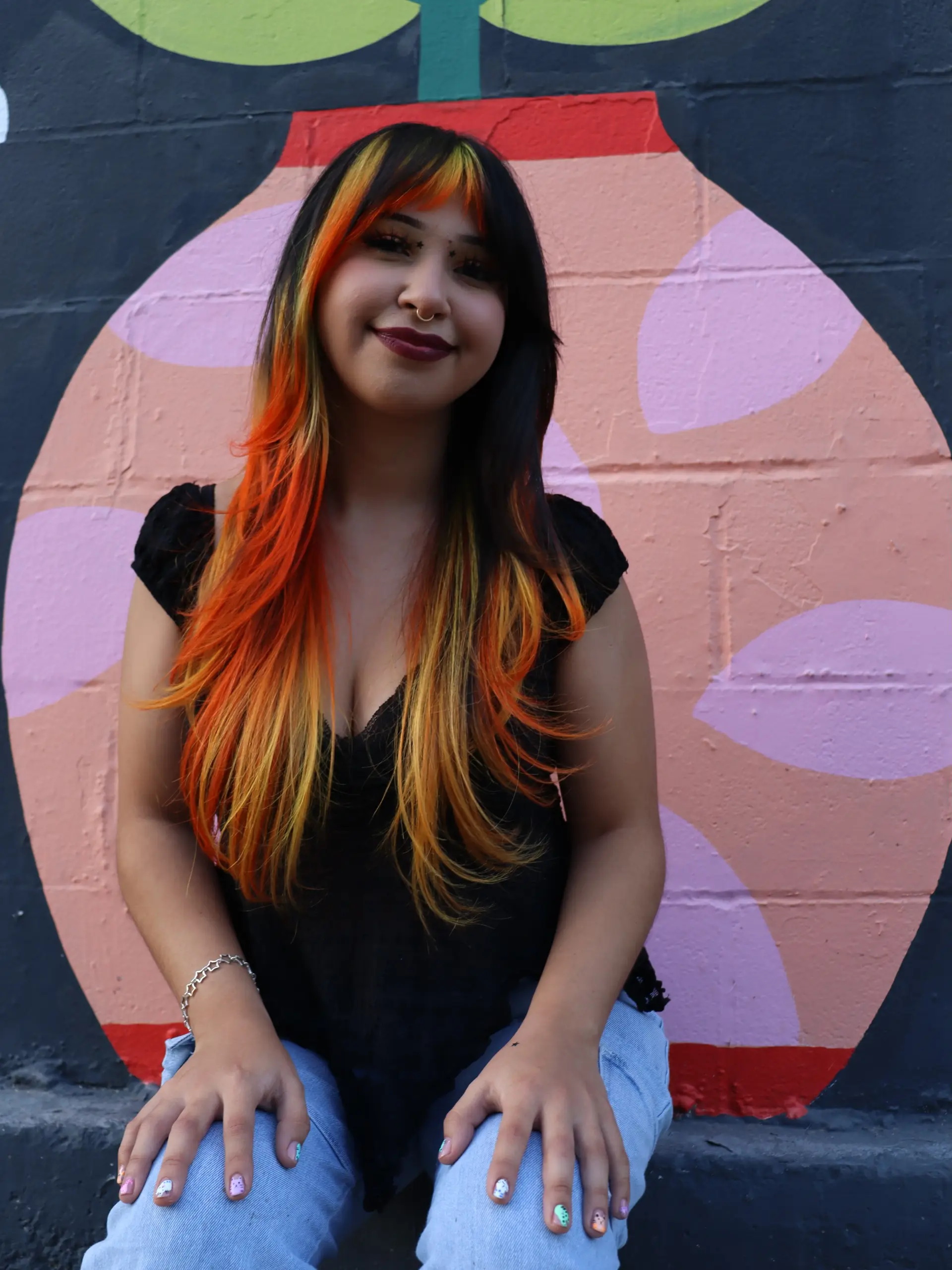 Long black hair accented with bright orange and yellow face-framing fire tones and full fringe bangs. 1