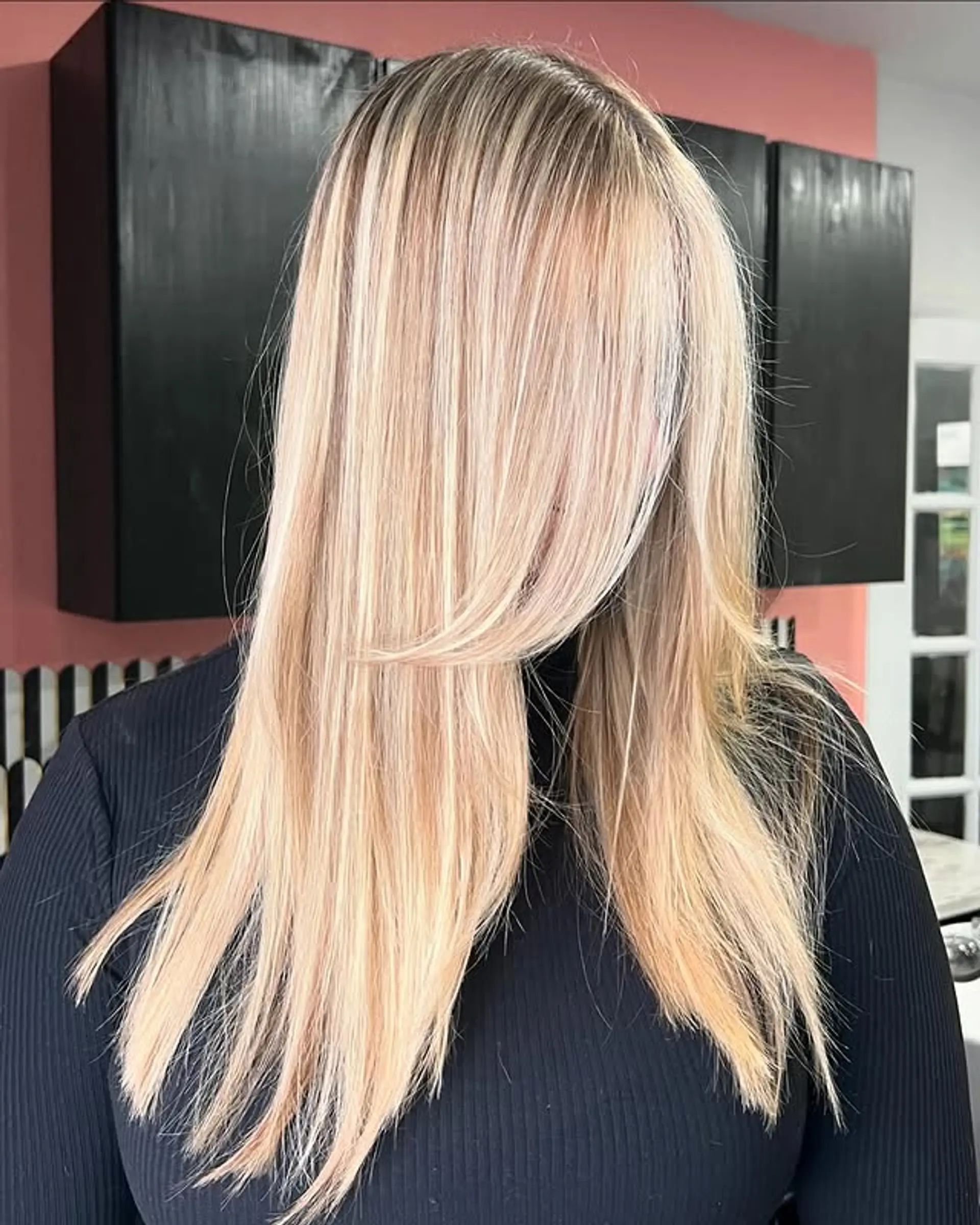 A long, straight hairstyle with face-framing layers and honey blonde balayage highlights. 1