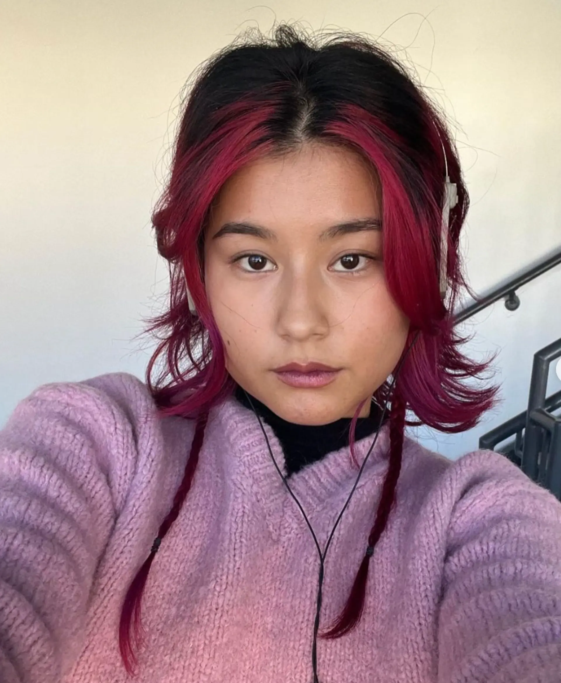 Vibrant medium-length wavy hairstyle with red highlights and two thin side braids. 1