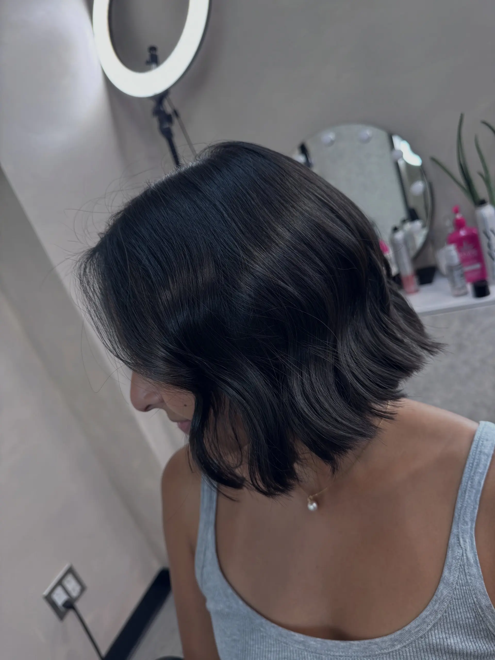A chic chin-length dark bob styled with soft, subtle waves and textured ends. 1