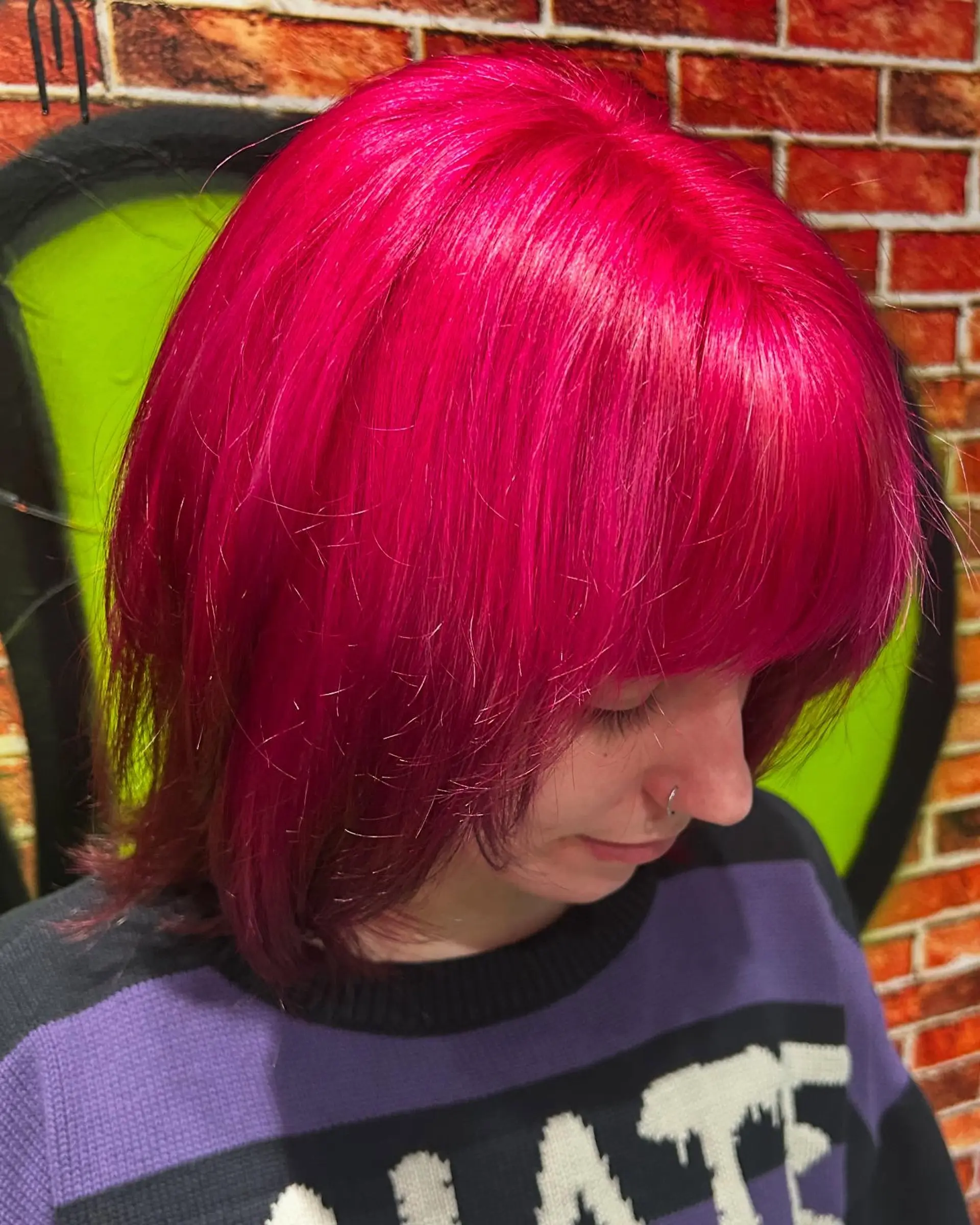 A vibrant all-over hot pink and magenta bob haircut styled straight with full front bangs. 1