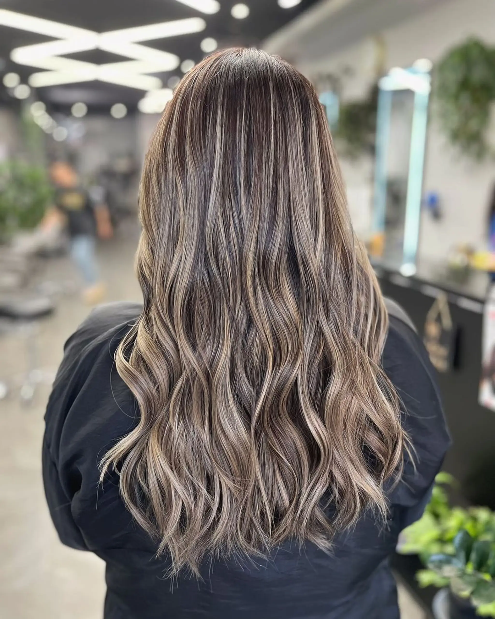 Long, wavy hair with ash brown base and blonde highlights, featuring loose waves, natural volume, and blended layers created with balayage.
Stylist - @xcellent_jason