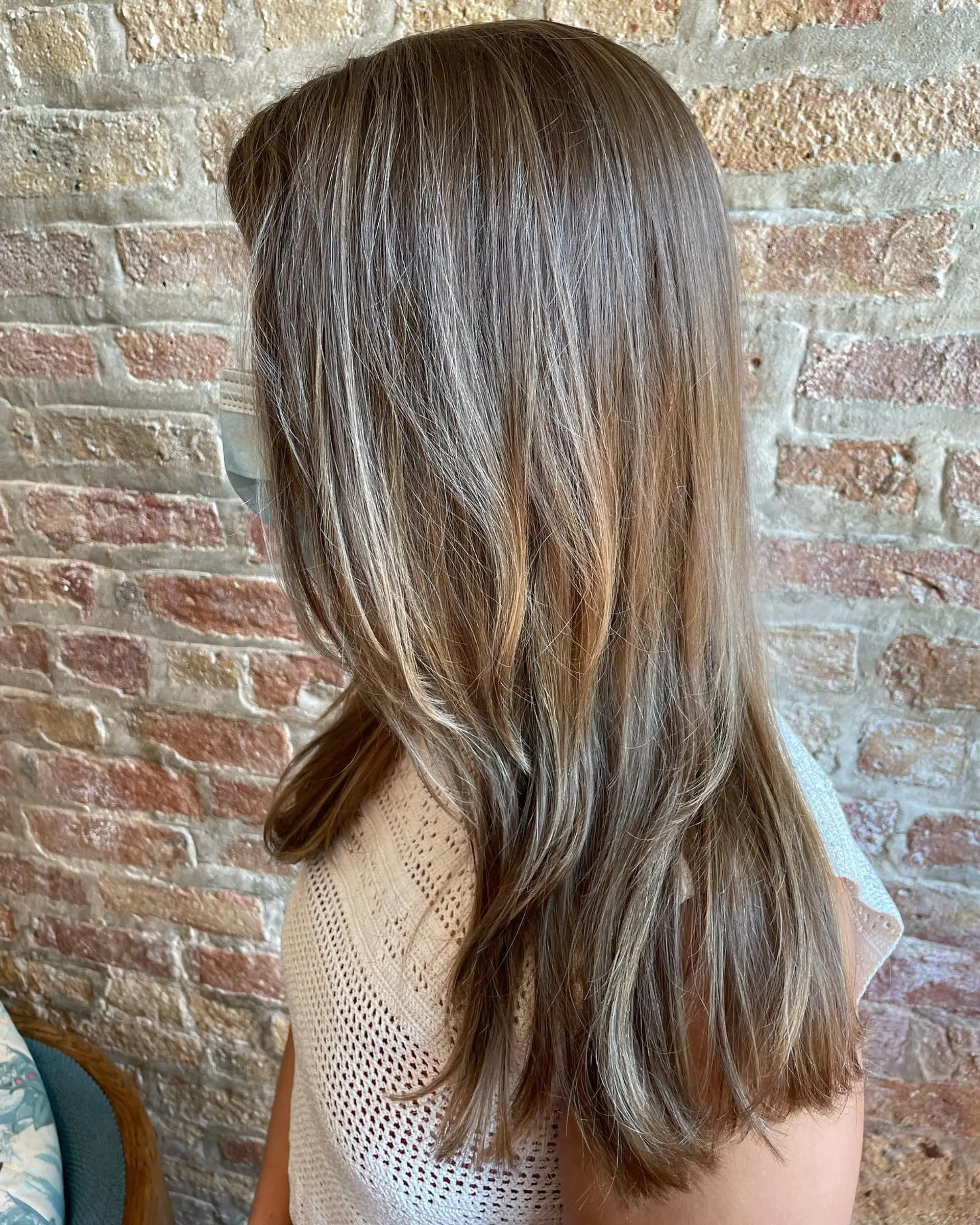 Long, straight hair with face-framing layers and a bronde balayage. 1
