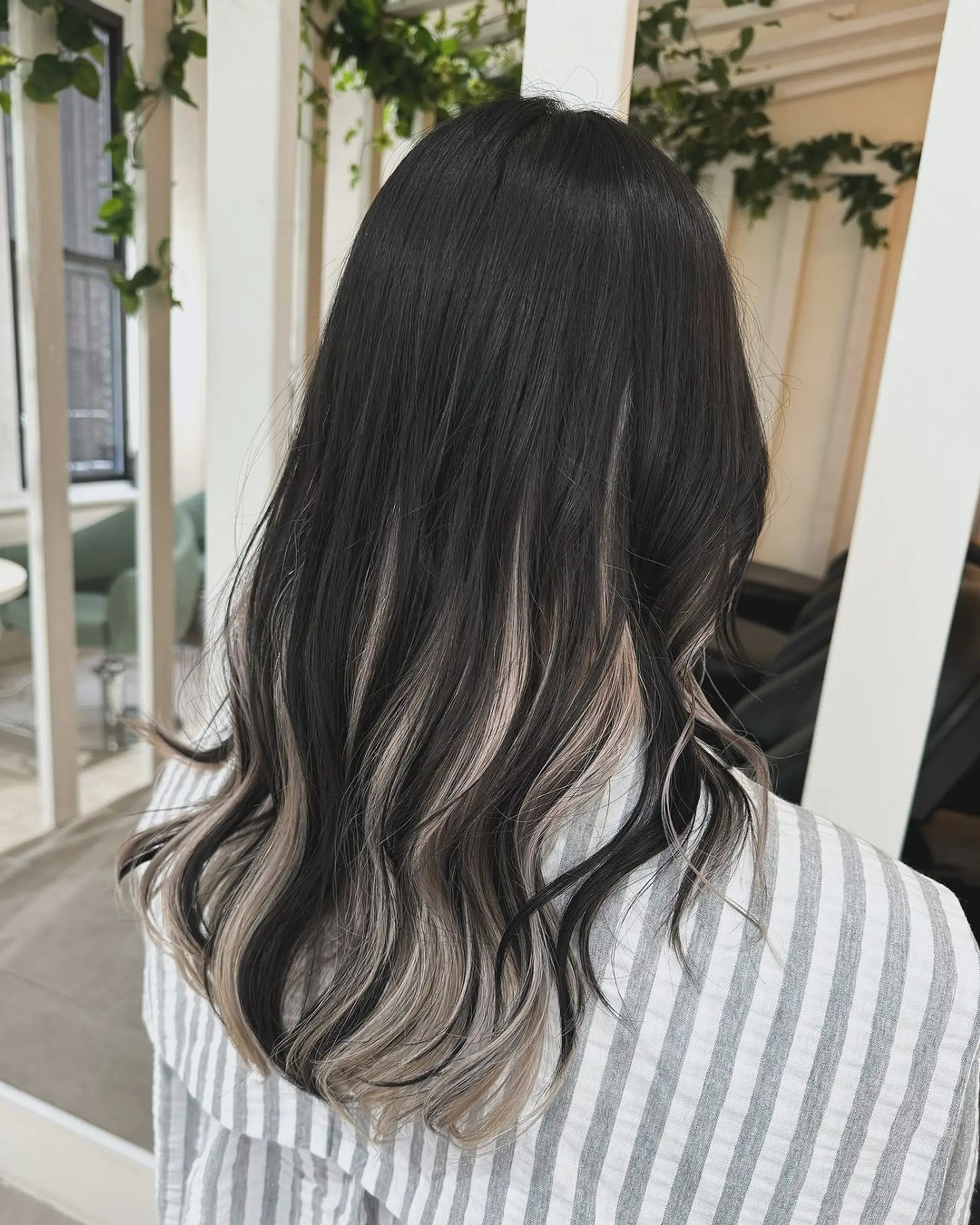A beautiful long, wavy ombre hairstyle with a black base transitioning to ash blonde, creating a striking two-tone effect. 1