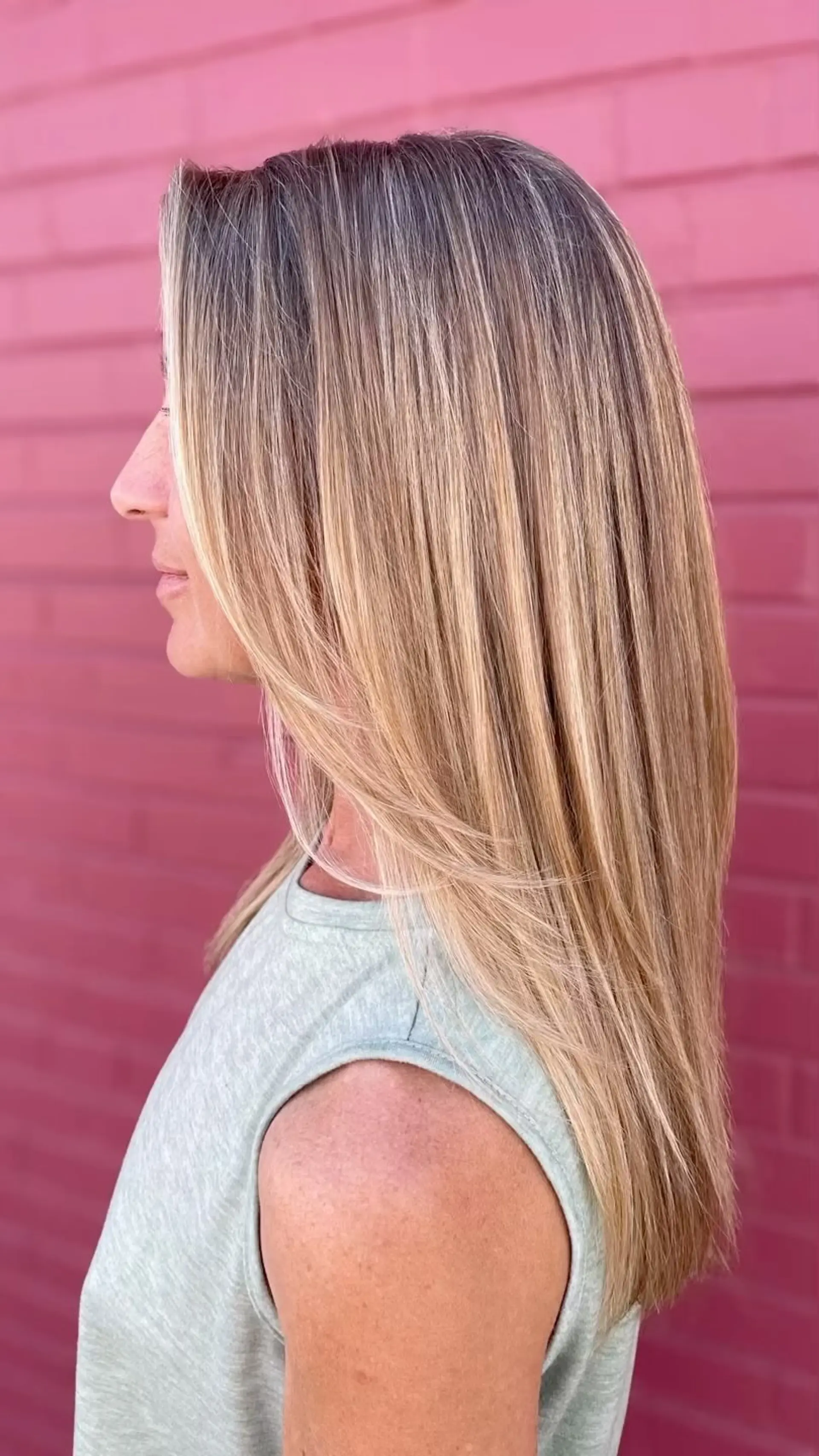 Long, straight hair featuring fine dimensional blonde highlights for seamless grey blending with soft face-framing layers. 1