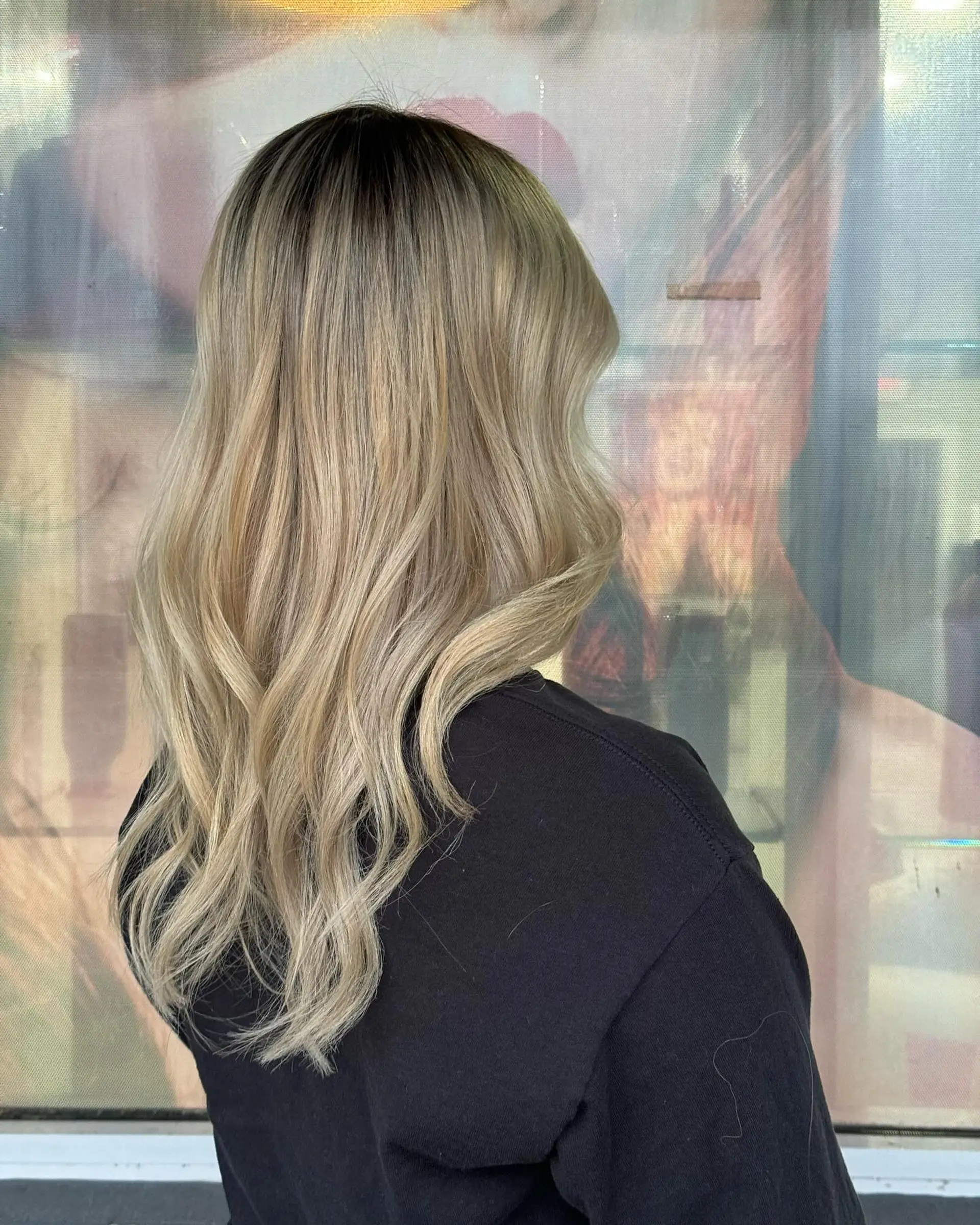 Long, wavy hair with a dark root ombre to blonde beach waves. 2