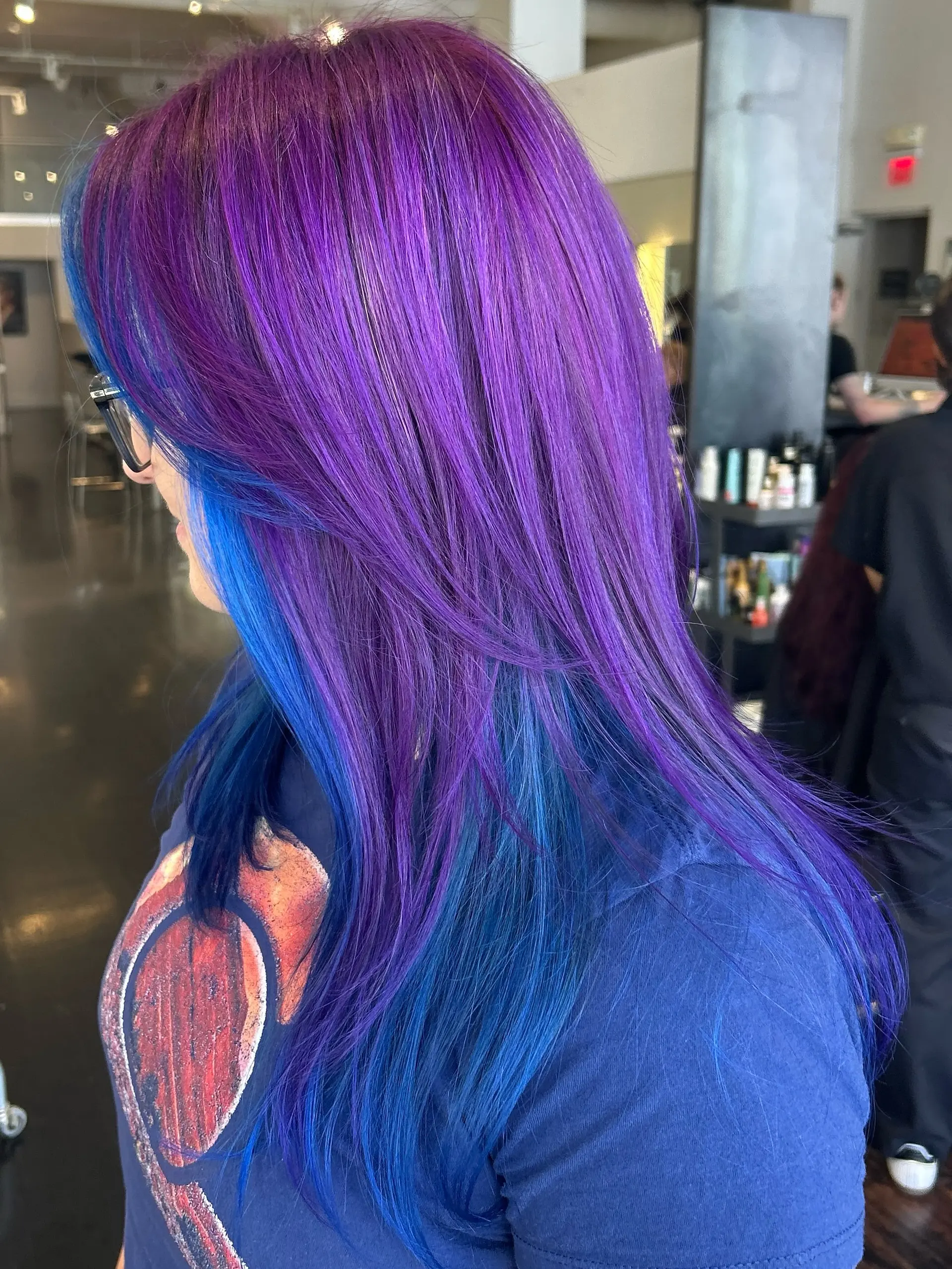 A vivid creative color featuring rich electric purple on top layered over bold cobalt blue peekaboo underlights. 1