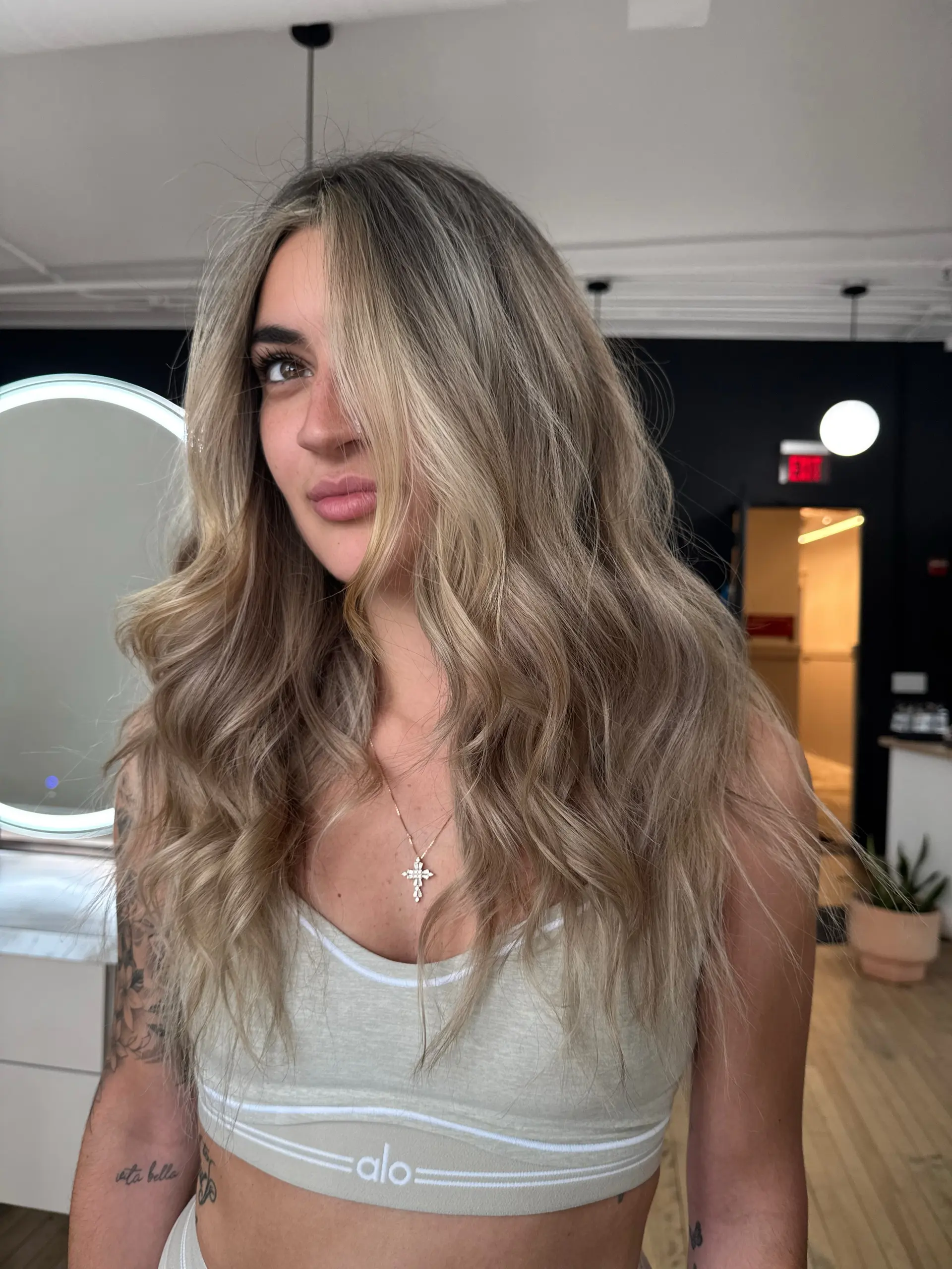 Long, flowing ash blonde hair styled in effortless beach waves with soft face-framing layers. 1