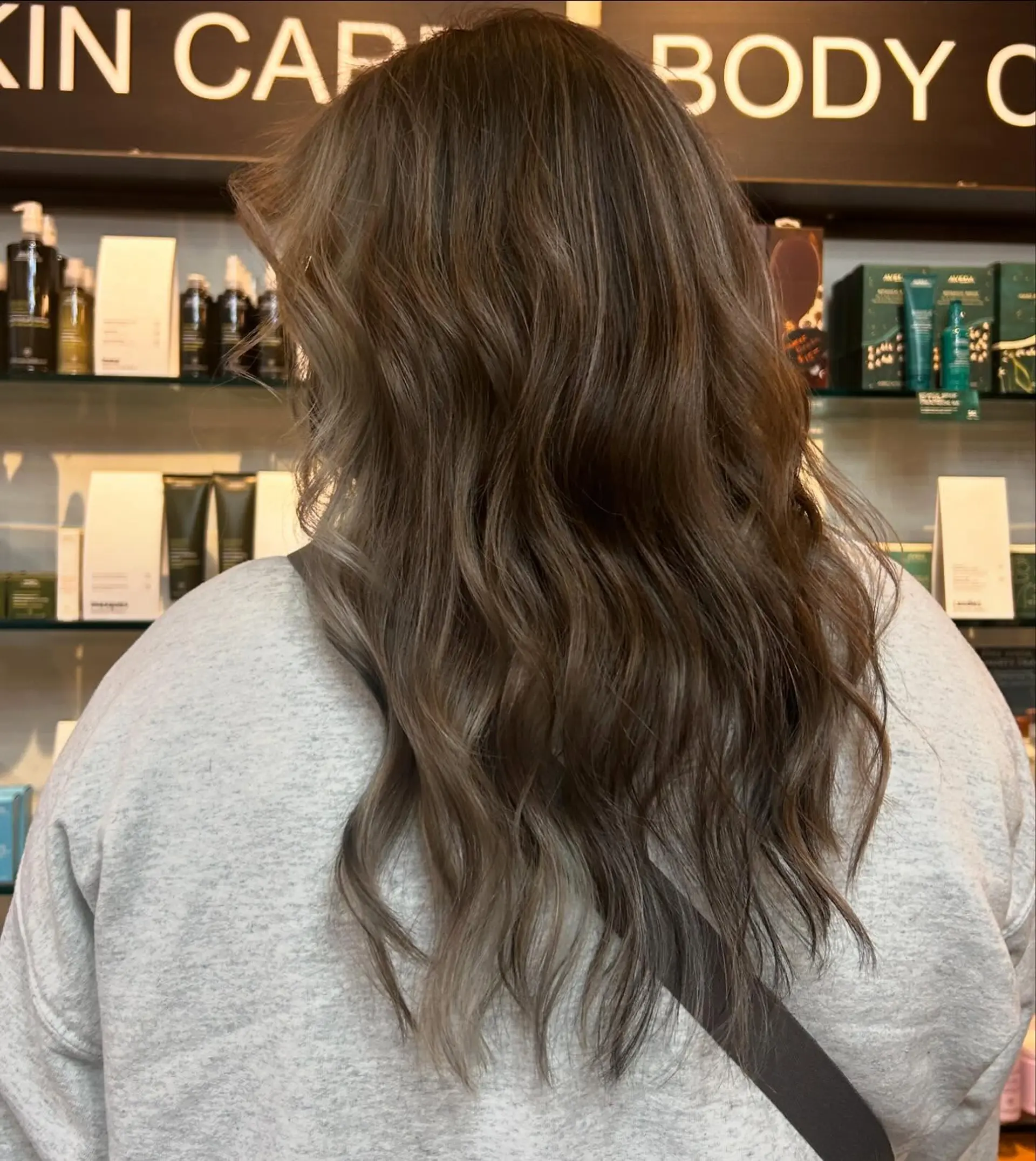 Long hair featuring a seamless, natural cool-toned ash brown balayage styled in soft, undone waves. 1