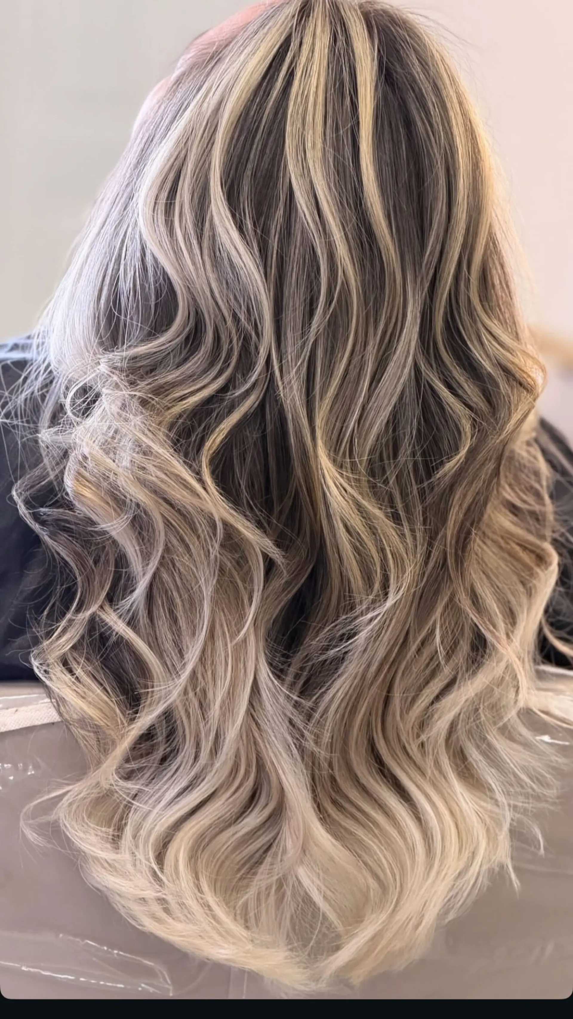 Long layered hair with cool-toned dimensional blonde balayage styled in soft textured waves. 1