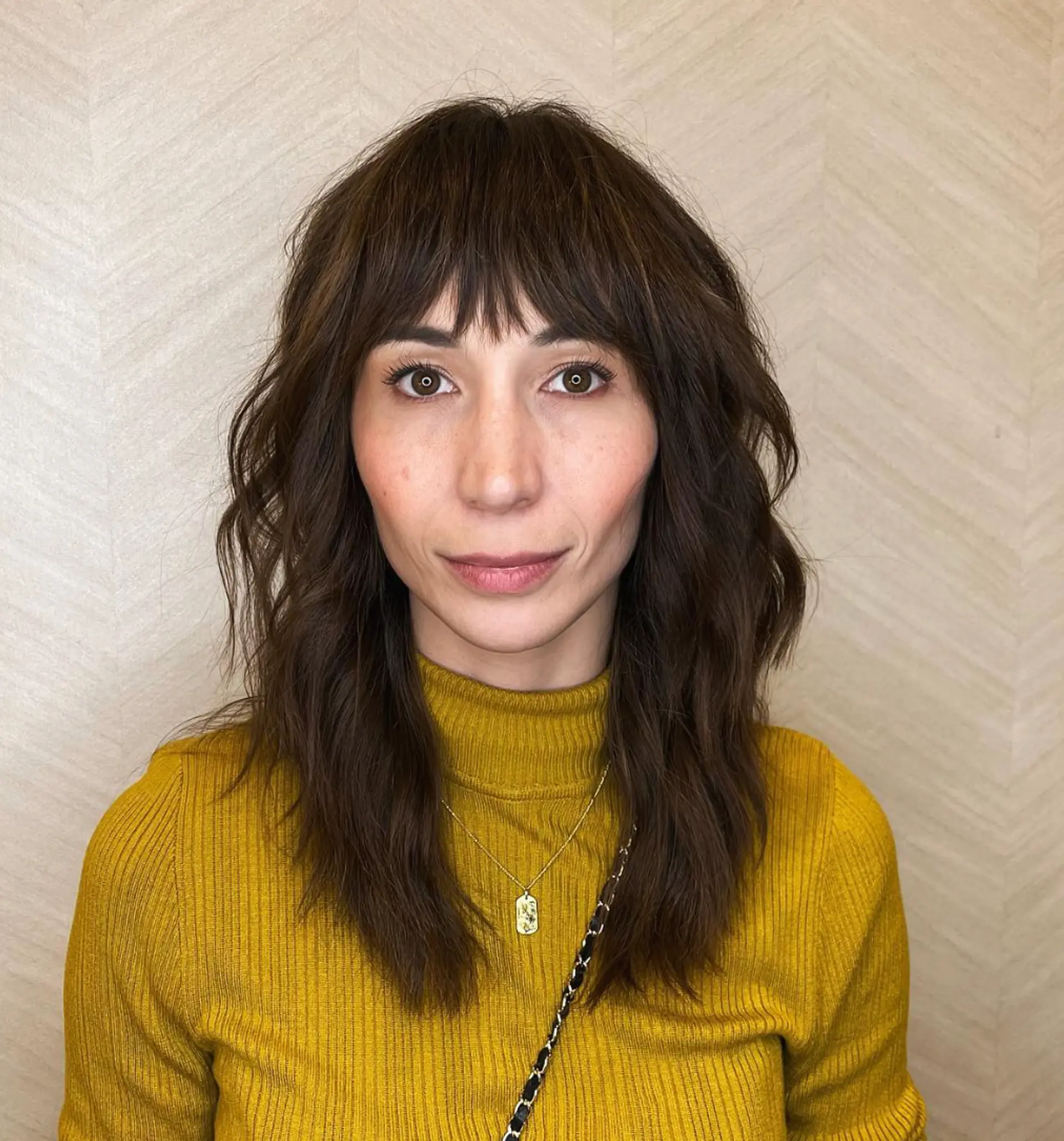 Medium-length, natural wavy brown hair with a full fringe, wavy texture, and shaggy layers for a chic, textured look.

Cut and style by @juliamannino_hair 1