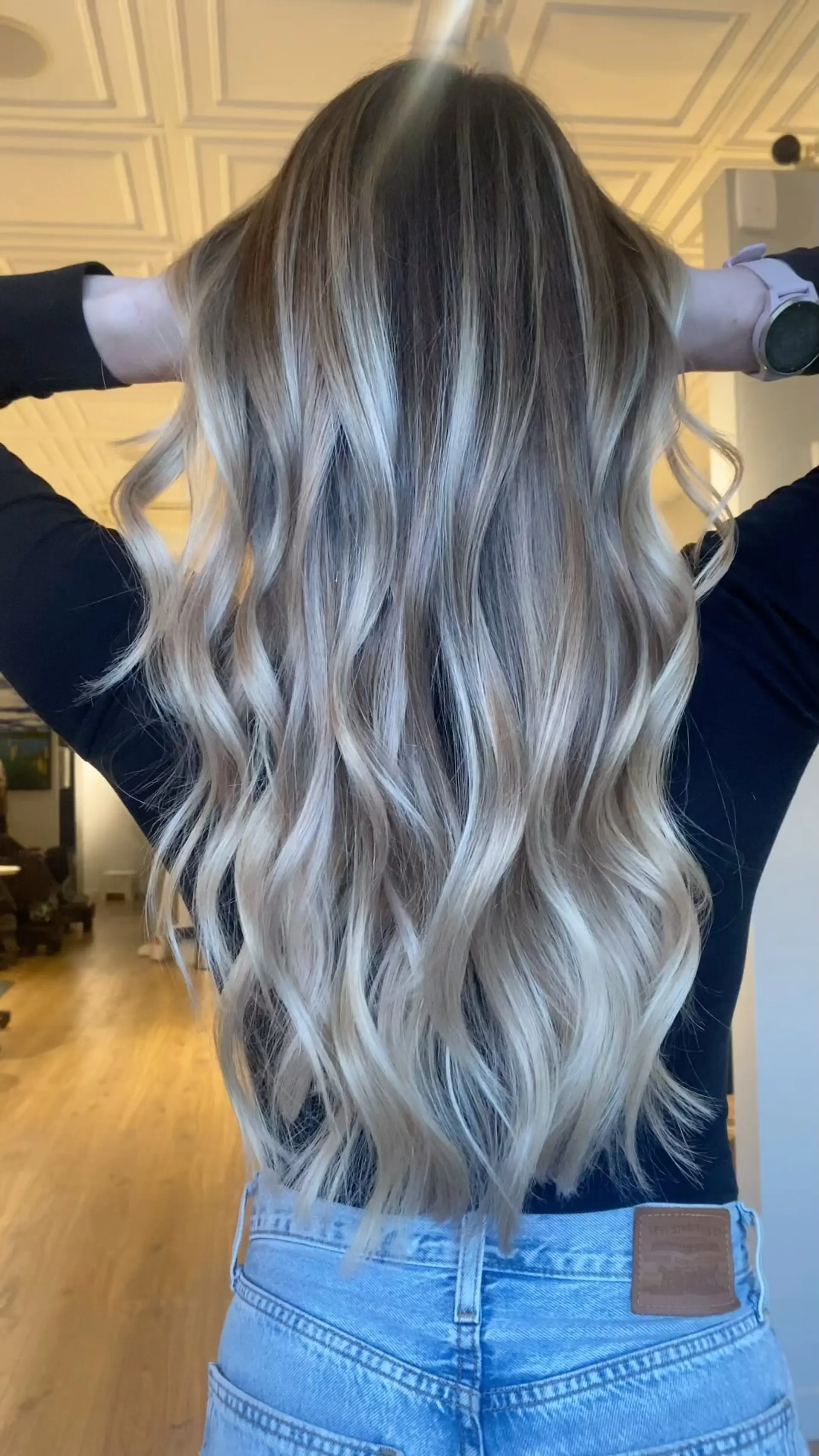 Long, flowing dimensional ash blonde balayage styled with relaxed, effortless beach waves. 1