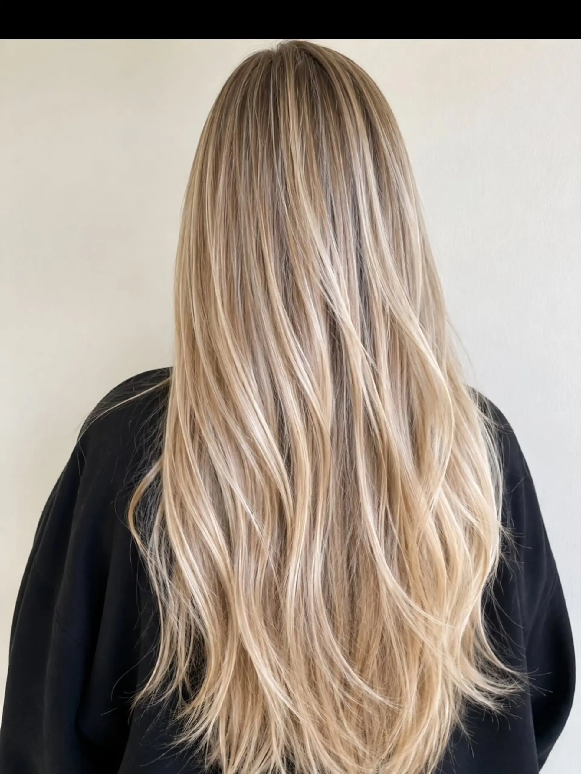 Long dimensional blonde hair with fine babylights and soft, subtle waves at the ends. 1