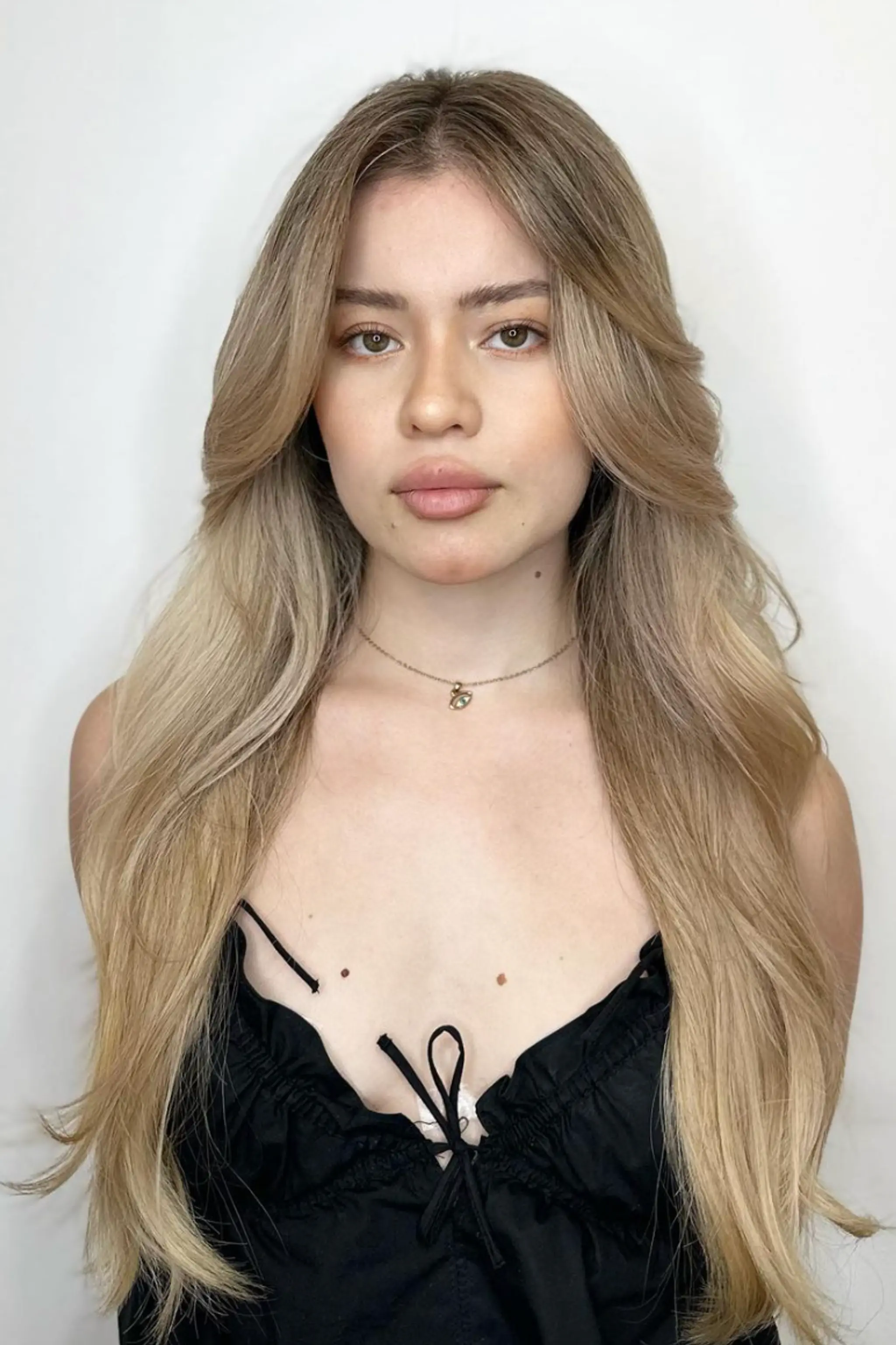 Long, wavy blonde hair with layers and side swept bangs, featuring soft waves and a natural look.

Color by @simabeautynyc
 2