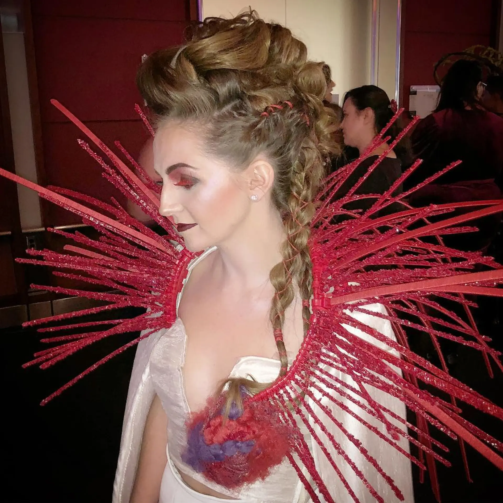 An avant-garde faux hawk updo with voluminous textured cresting and a side braid accent. 1