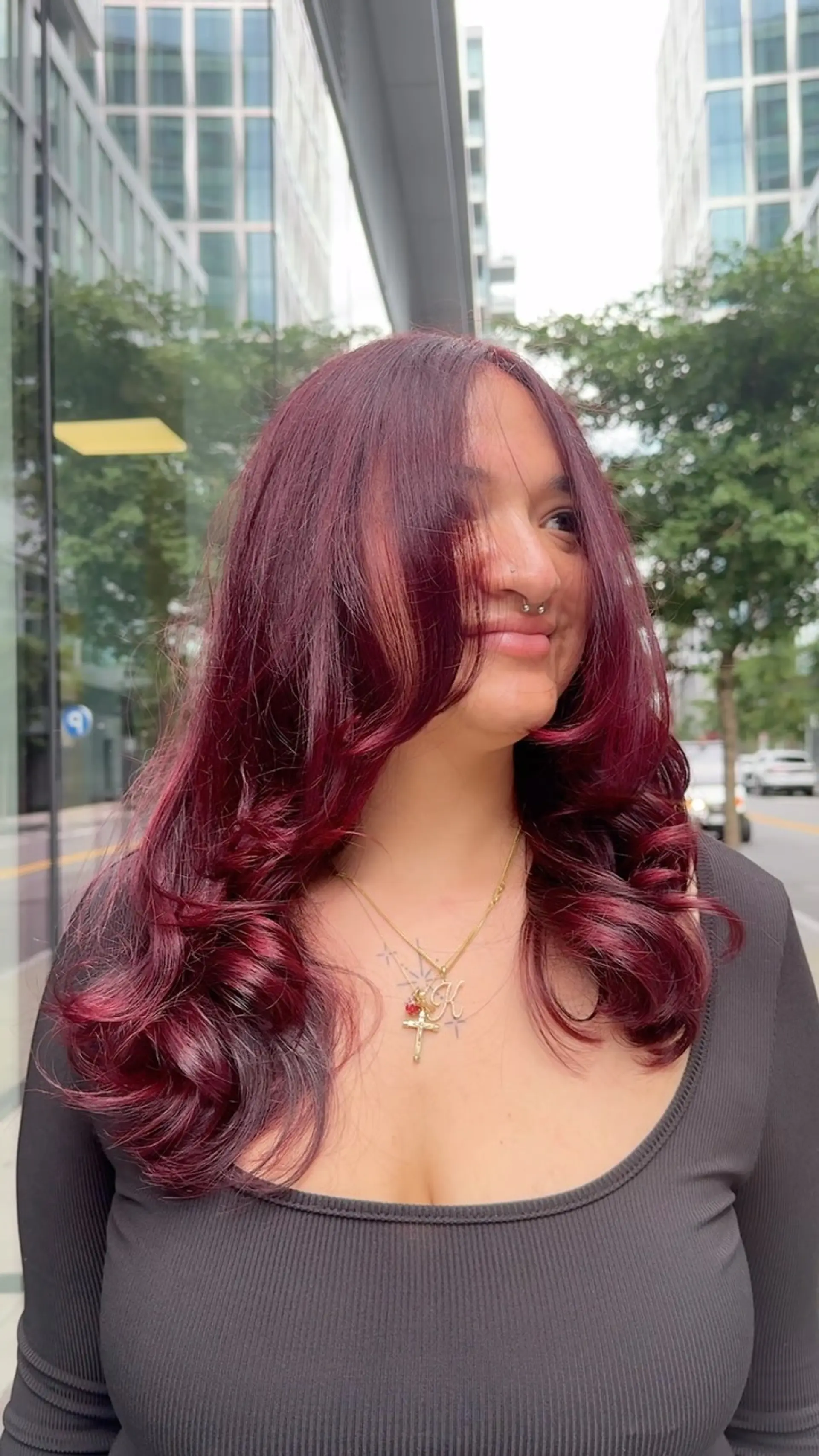 Deep burgundy layered hair styled with voluminous face-framing fringe and bouncy curls. 1
