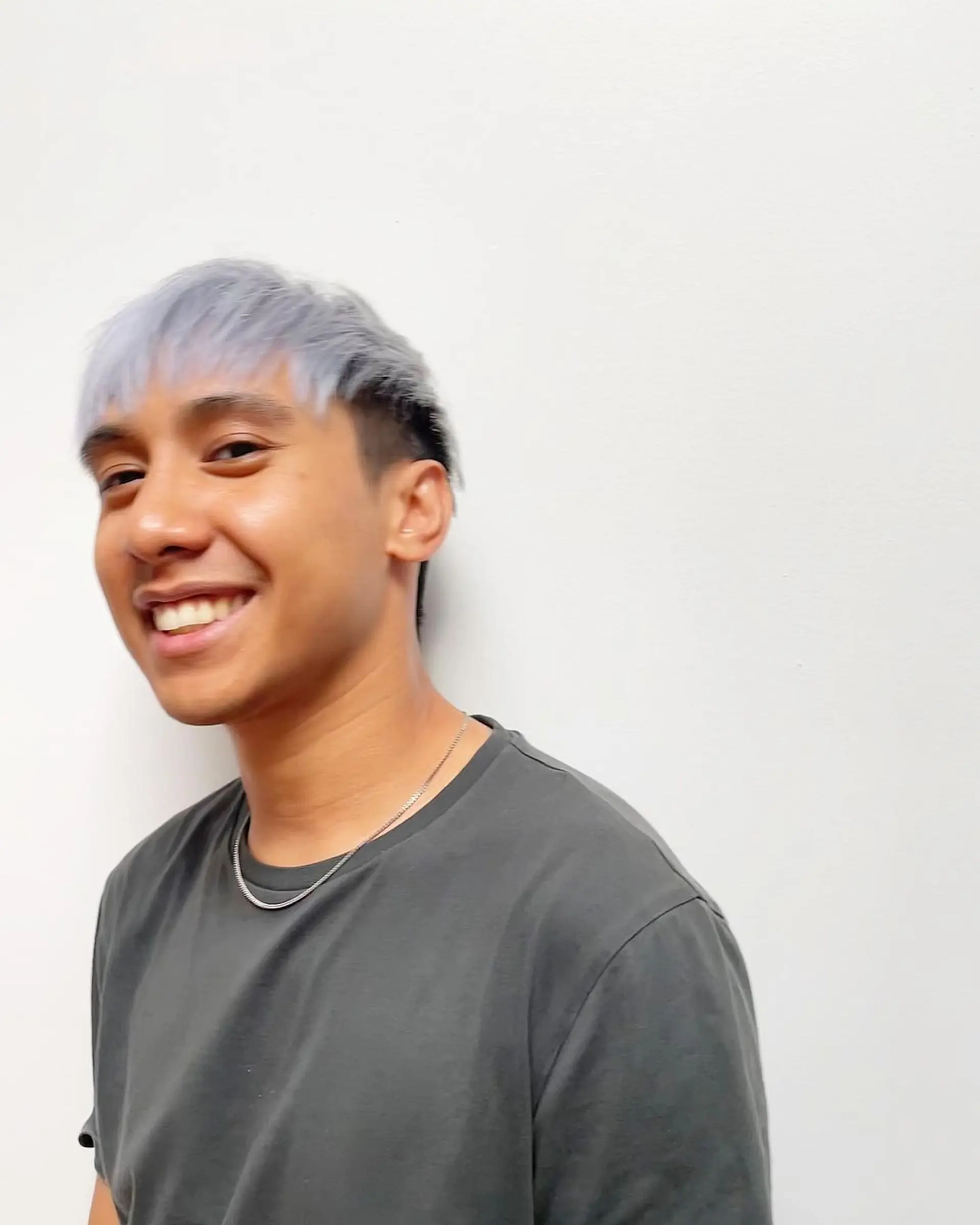 A modern and stylish short haircut characterized by straight silver and platinum colors, with a frosted fringe, dark undercut sides, and neatly layered top sections swept slightly to the side. 2