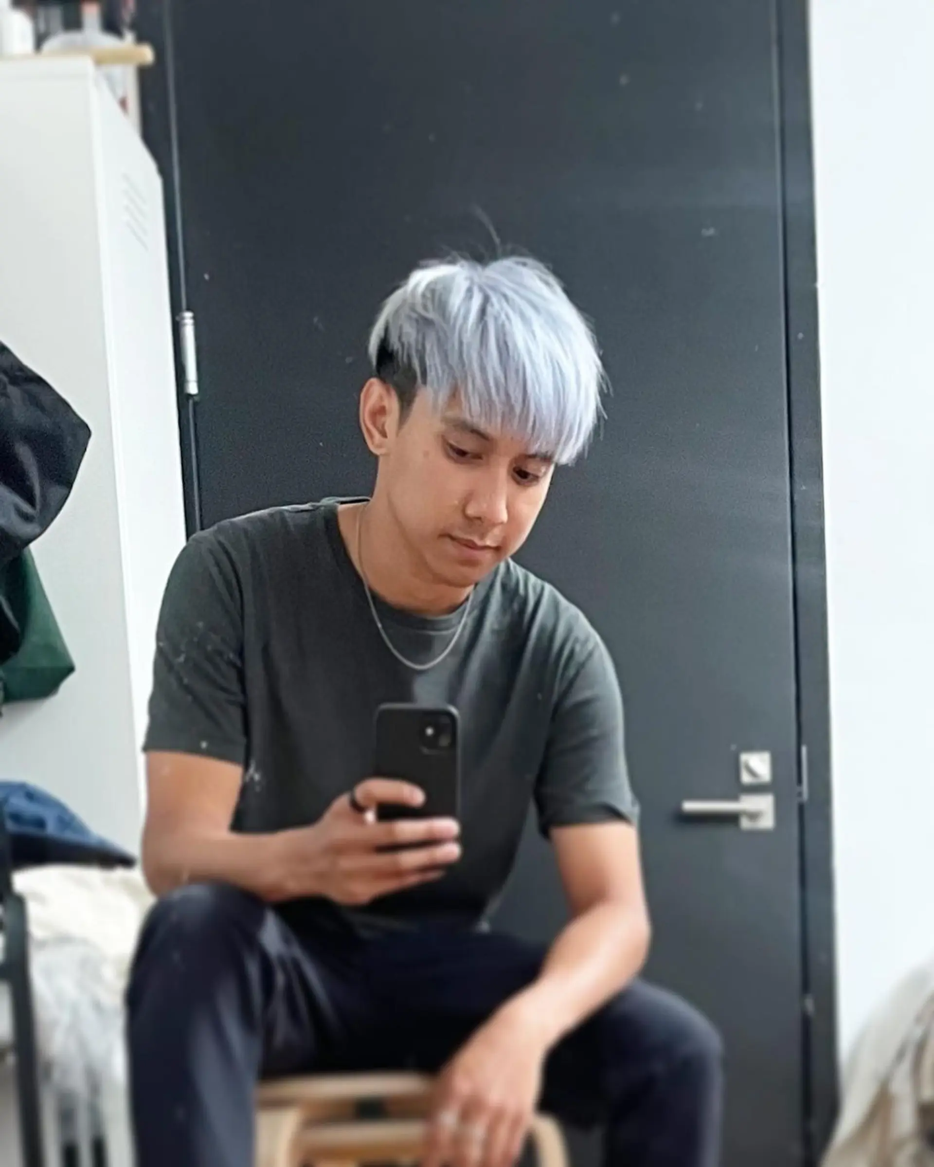 A modern and stylish short haircut characterized by straight silver and platinum colors, with a frosted fringe, dark undercut sides, and neatly layered top sections swept slightly to the side. 3