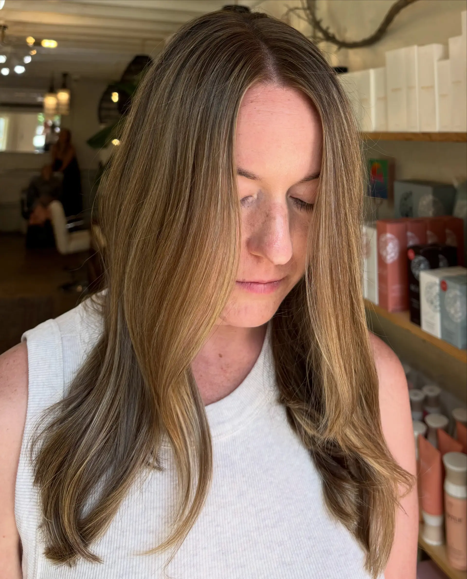 Long bronde hair featuring soft, dimensional warm highlights and face-framing layers styled into a smooth blowout. 1