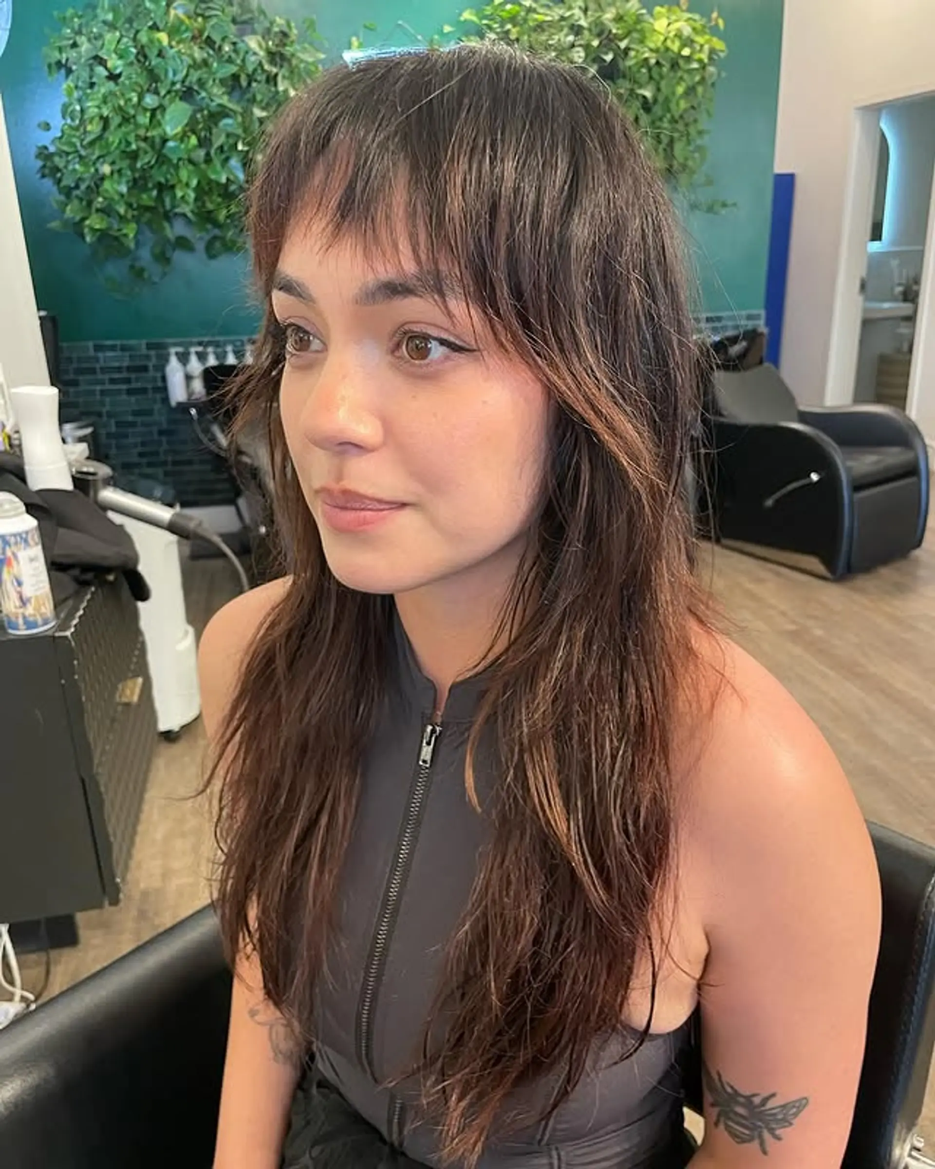 A trendy shag haircut with choppy layers and short, blunt baby bangs. 1