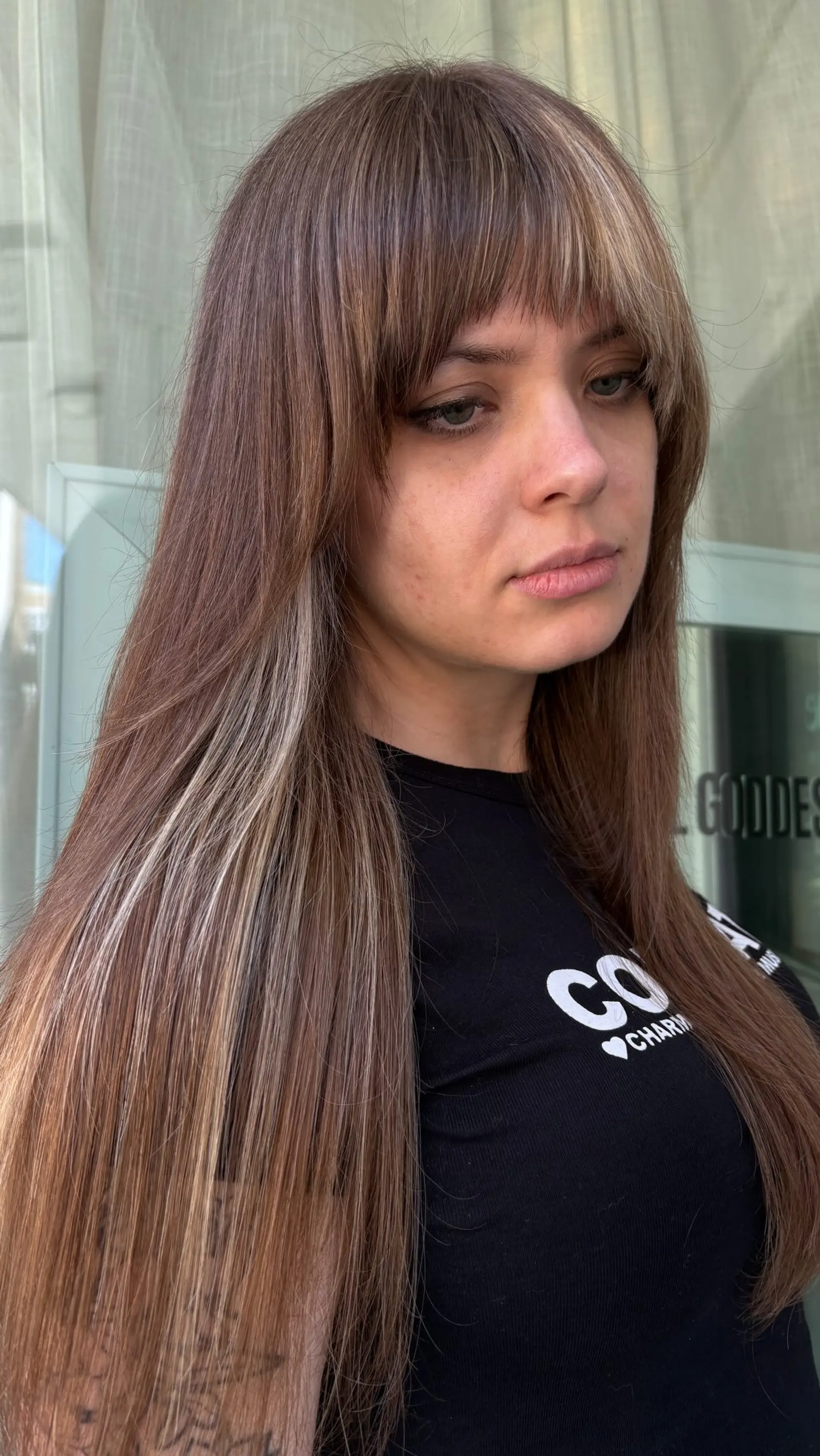Long straight brunette hair cut with full bangs and contrasting blonde block highlights. 1