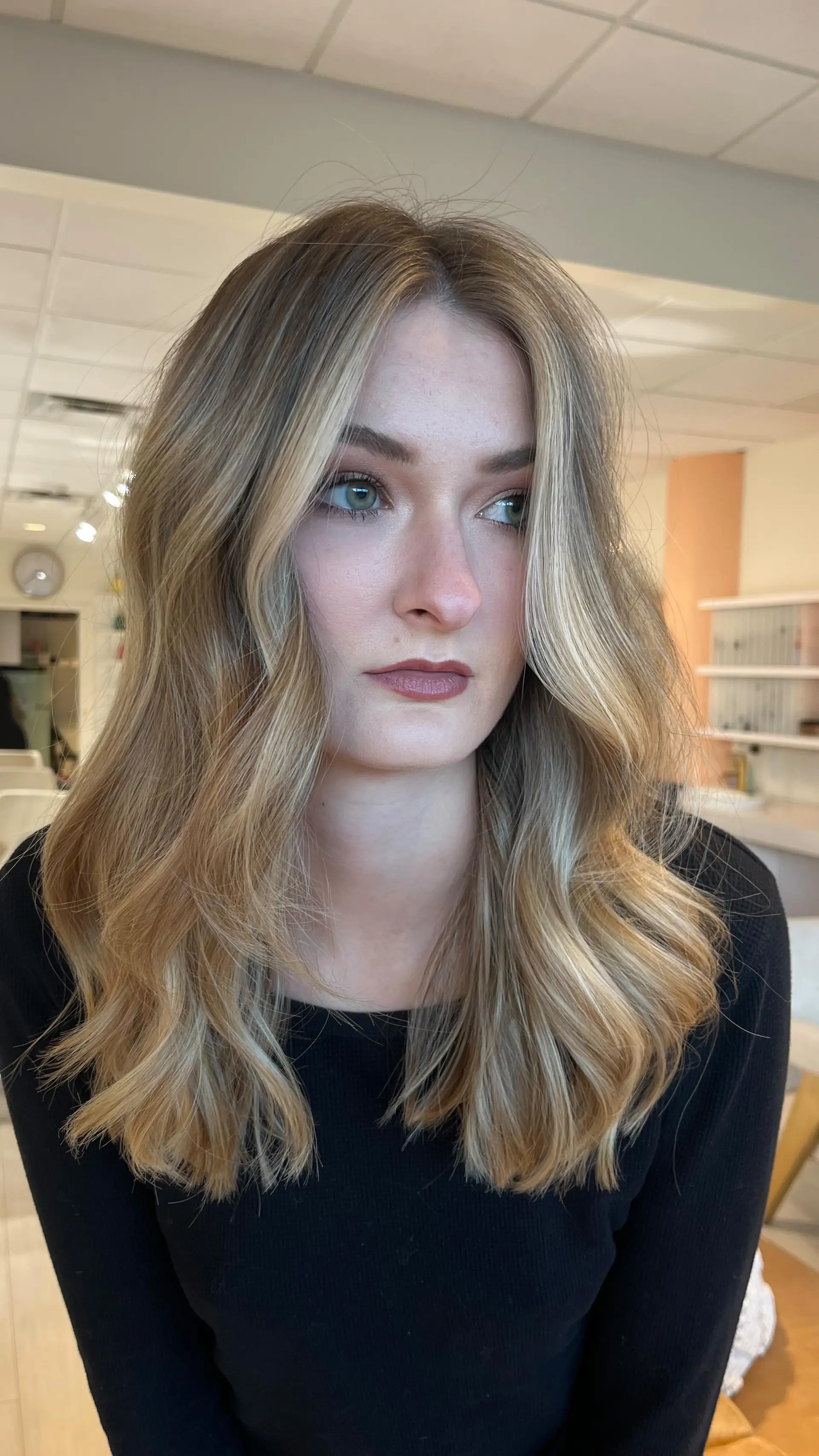 Long dimensional blonde hair styled in soft, loose waves with bright face-framing highlights. 1
