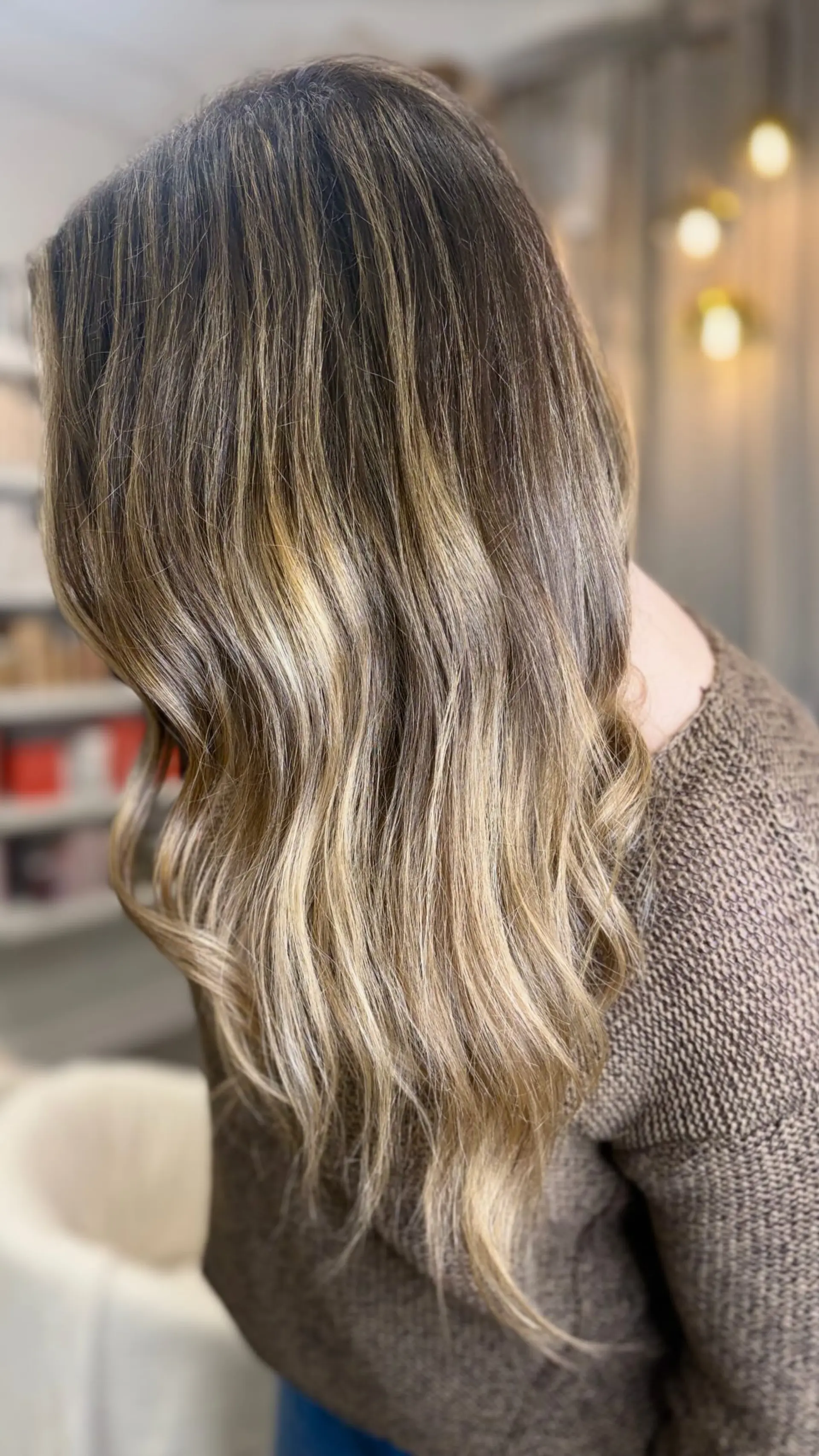 Long wavy hair with a soft root shadow blending seamlessly into dimensional blonde balayage highlights. 1