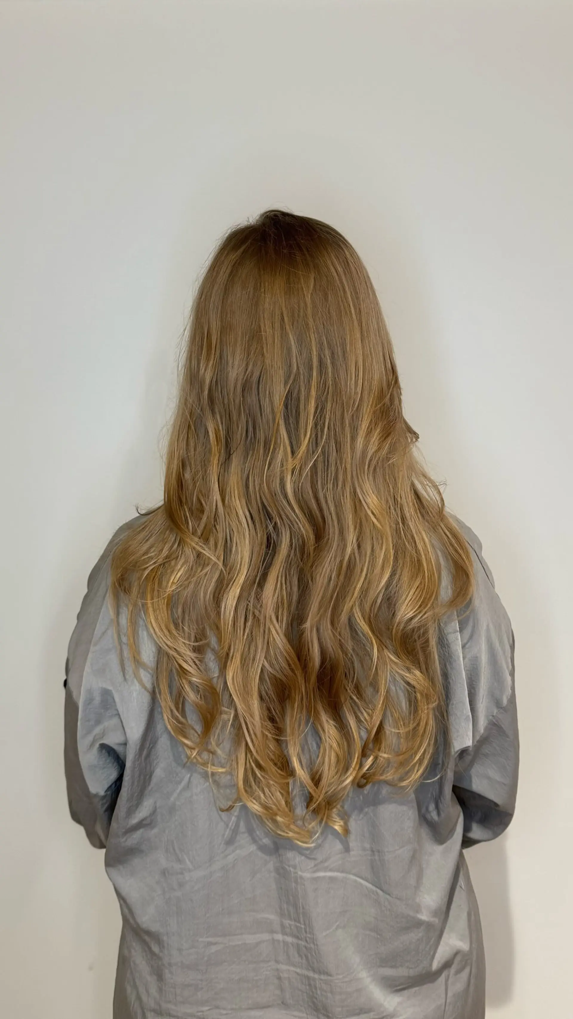 Long caramel blonde hair styled with soft, cascading loose waves and layered ends. 1