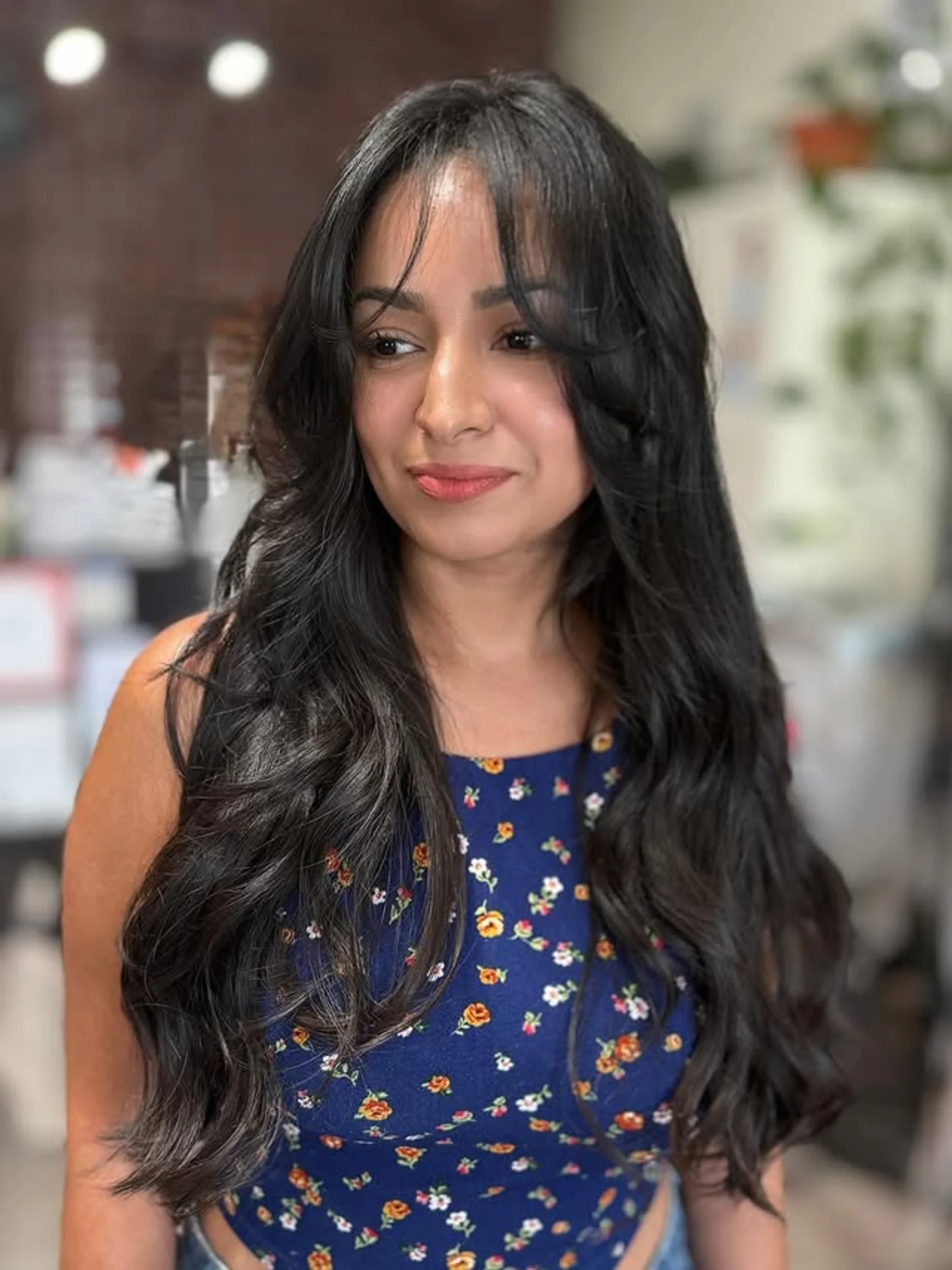 Long blonde hair styled with beach waves, long layers, and curtain bangs - Preview 2