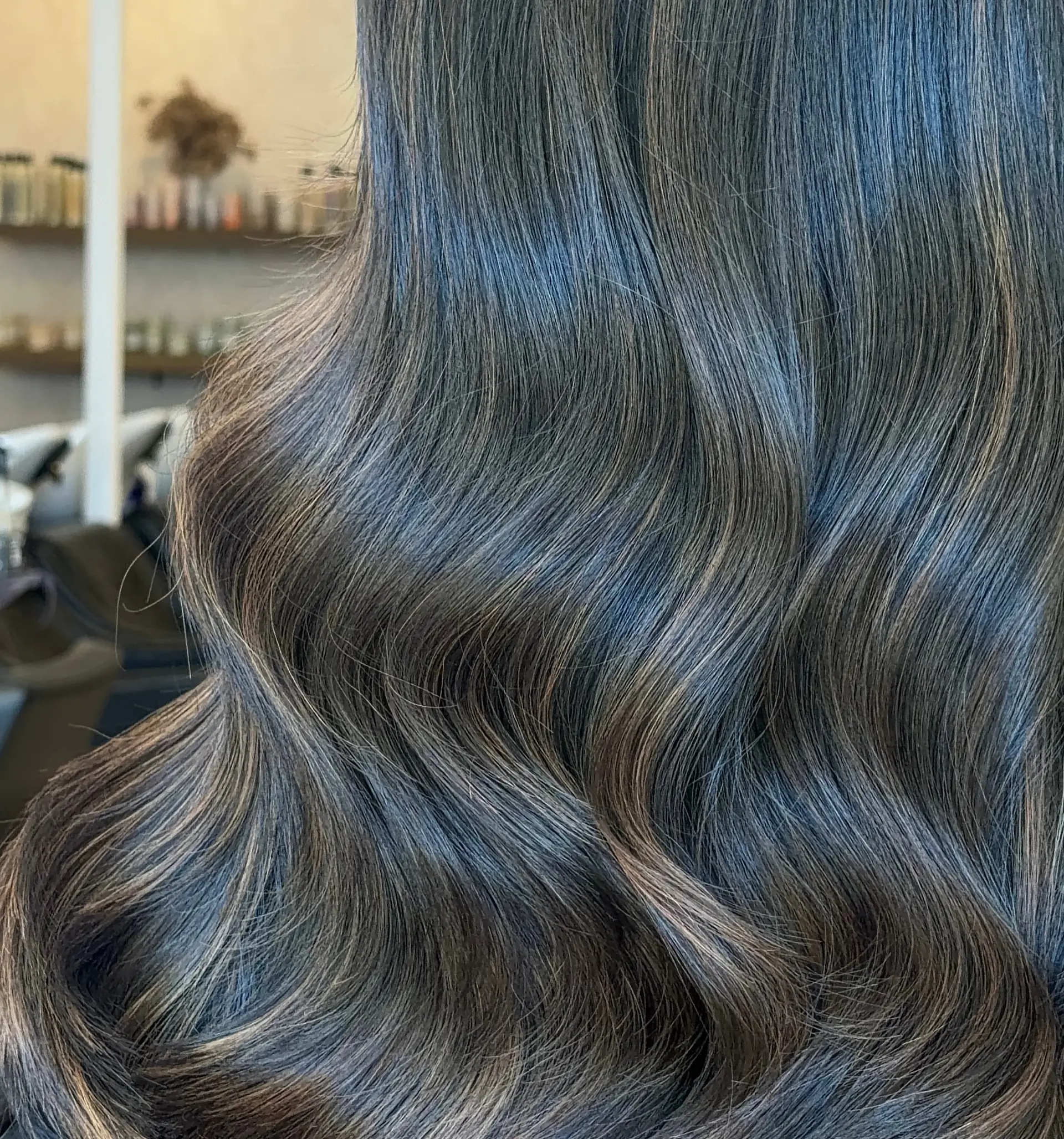 Glossy, deep brunette hair styled in soft, smooth waves with subtle warm dimensional highlights. 1