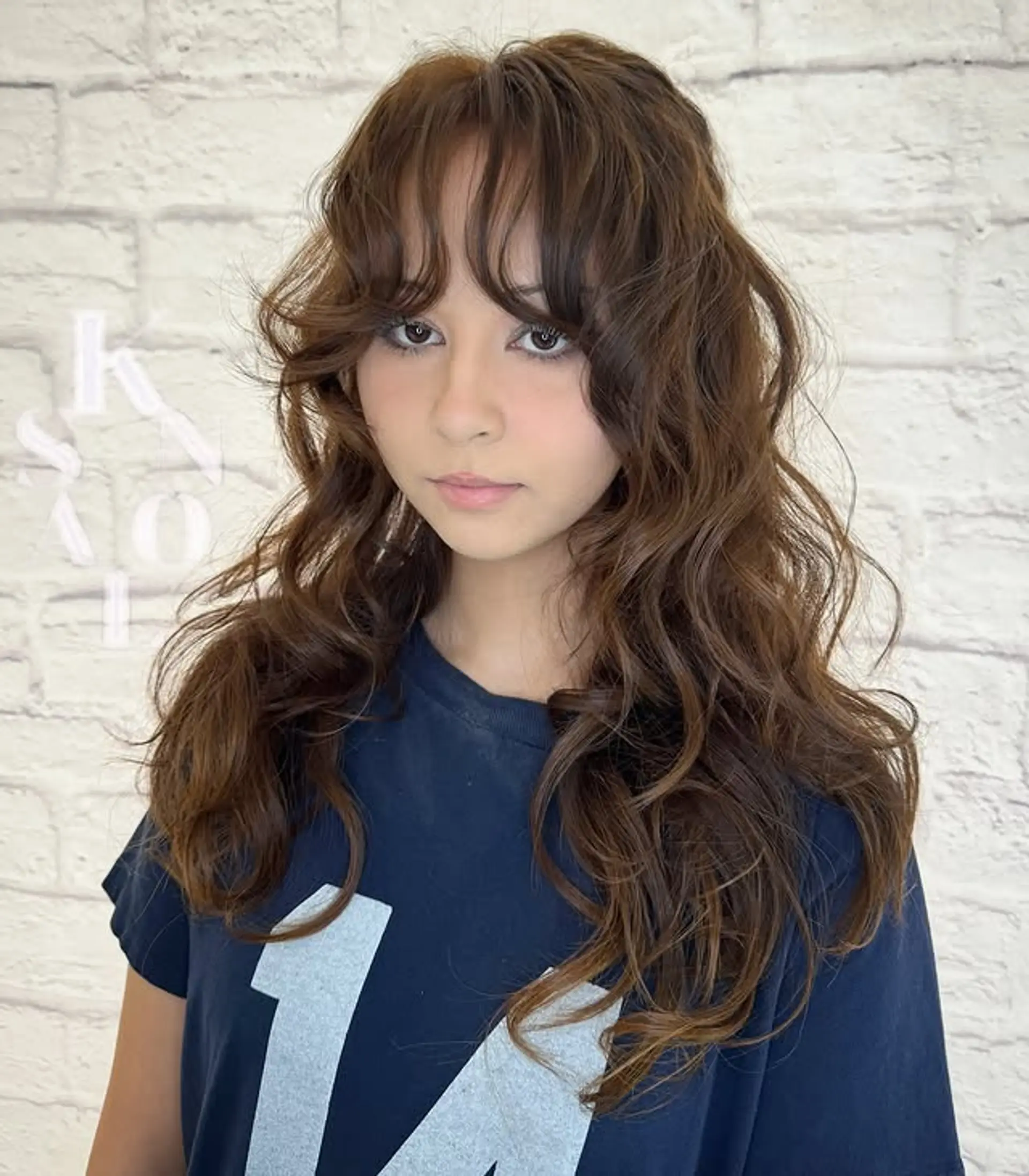 A stylish long shag haircut with soft waves and face-framing curtain bangs. 1