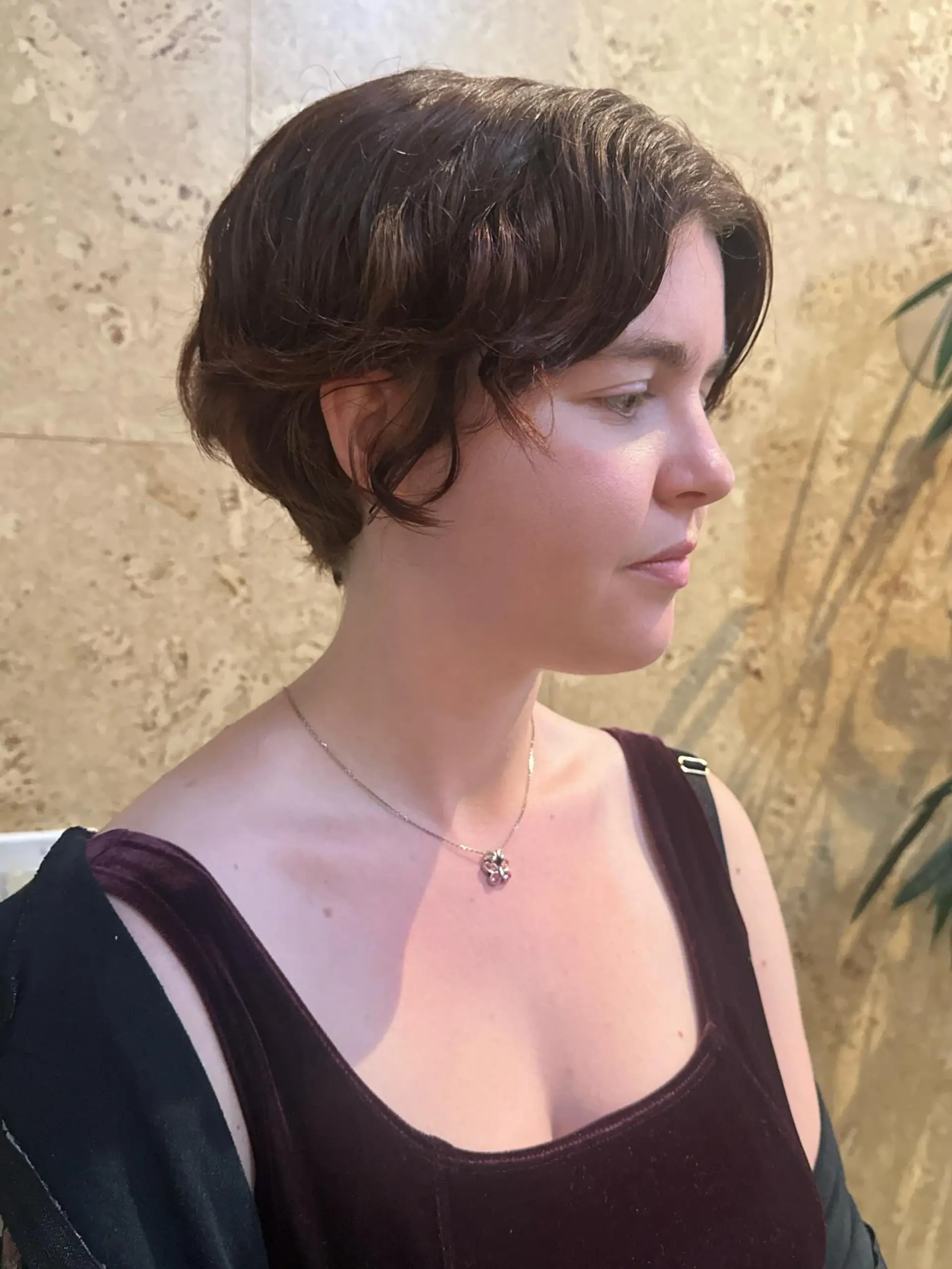 Short textured dark brown pixie cut with soft face-framing waves. 1