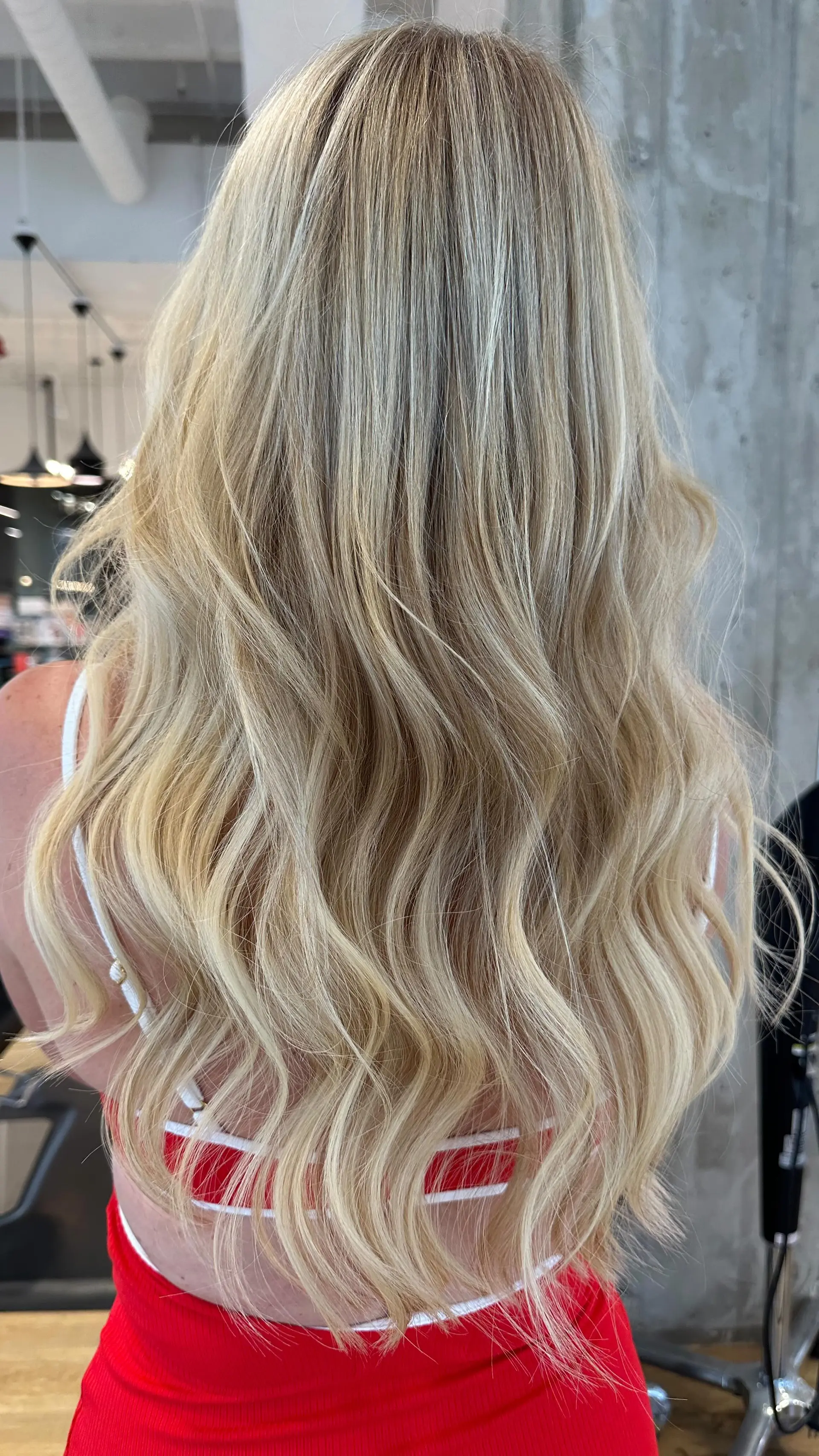 Long blonde hair styled in loose, dimensional waves with seamlessly blended highlights. 1