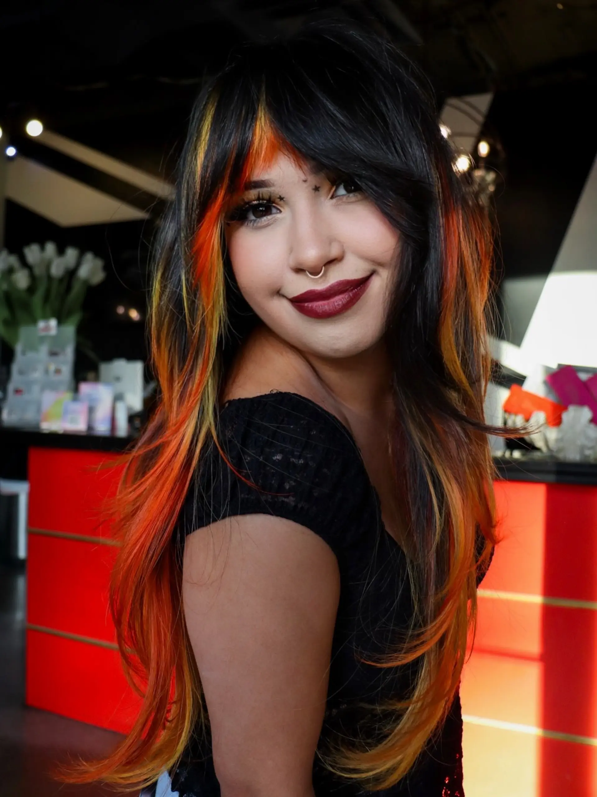 Long layered black hair featuring vivid orange, yellow, and red tipped layers with matching fiery textured bangs. 1