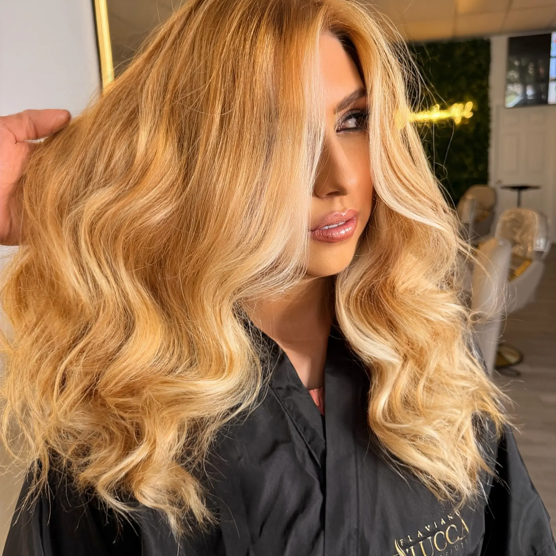 Long golden honey blonde hair styled in voluminous, smooth waves with face-framing brightness. 1