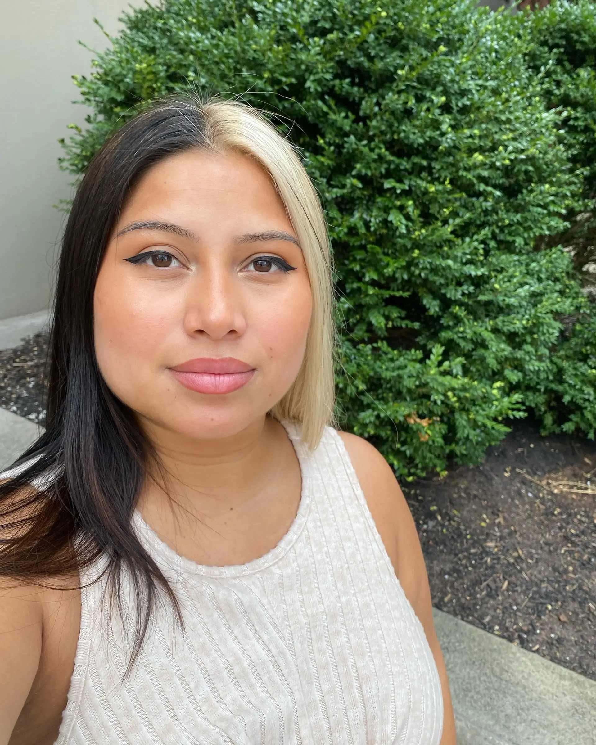 A straight split-dye look parted down the middle, with one half colored deep black and the opposing half in platinum blonde. 1